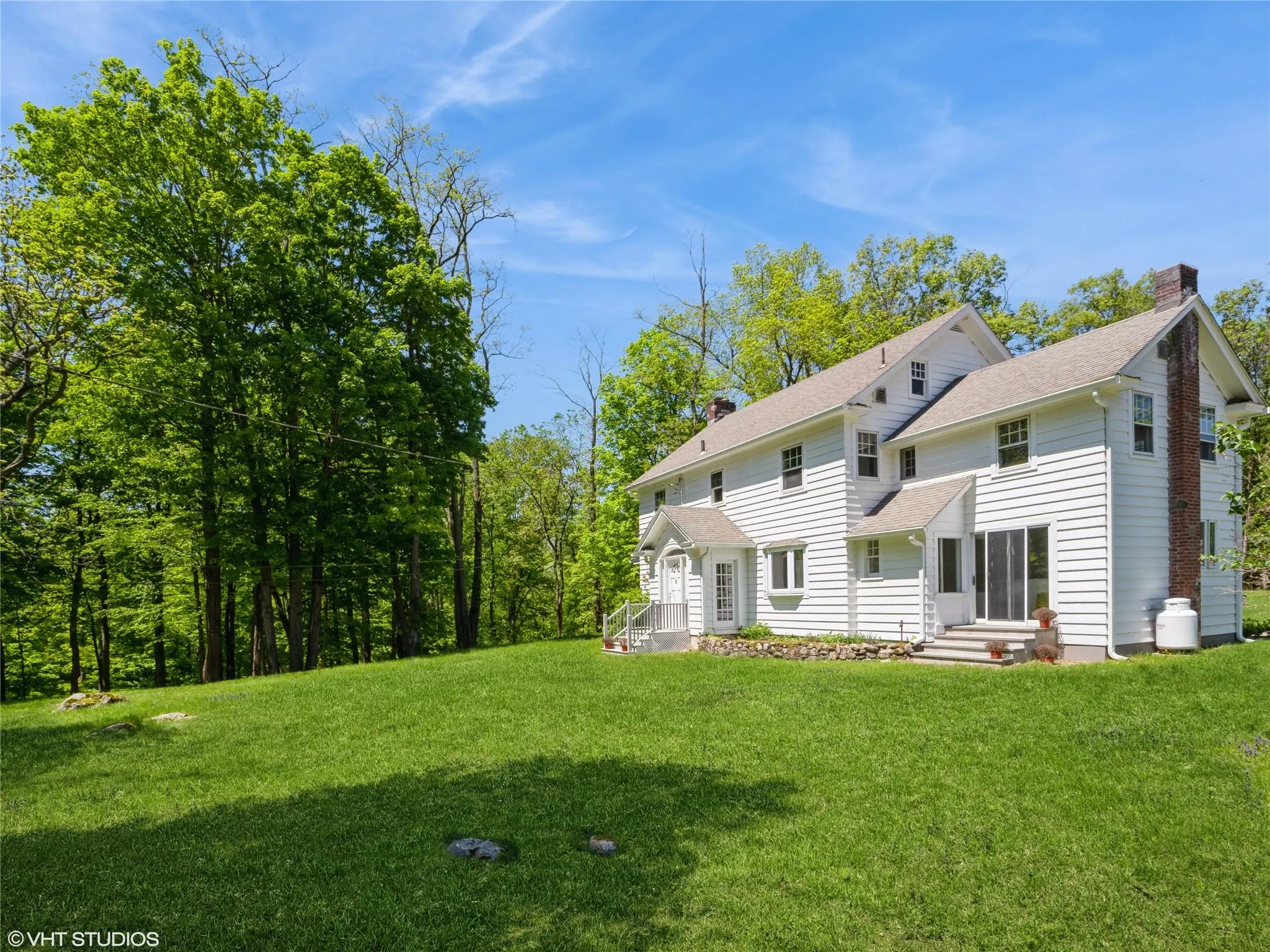 Back of house with a chimney, a yard, and roof with shingles Back of house with a chimney, a yard, and roof with shingles