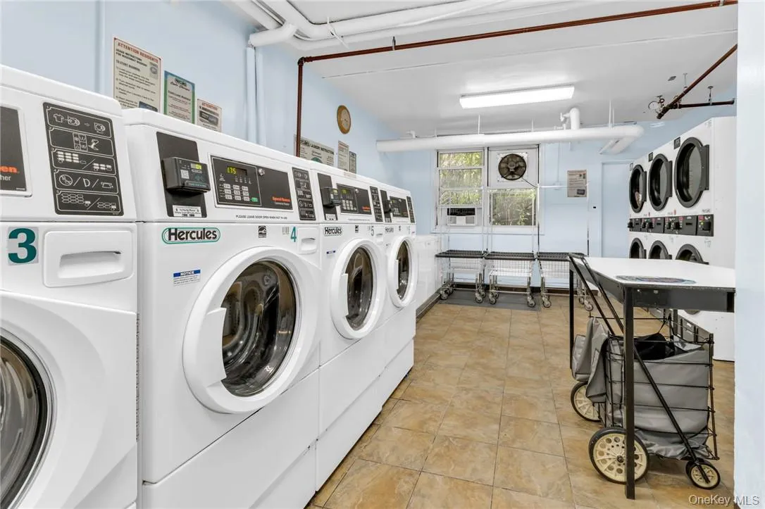 Laundry room featuring stacked washer and clothes dryer, washing machine and dryer, and light tile patterned floors Laundry room featuring stacked washer and clothes dryer, washing machine and dryer, and light tile patterned floors