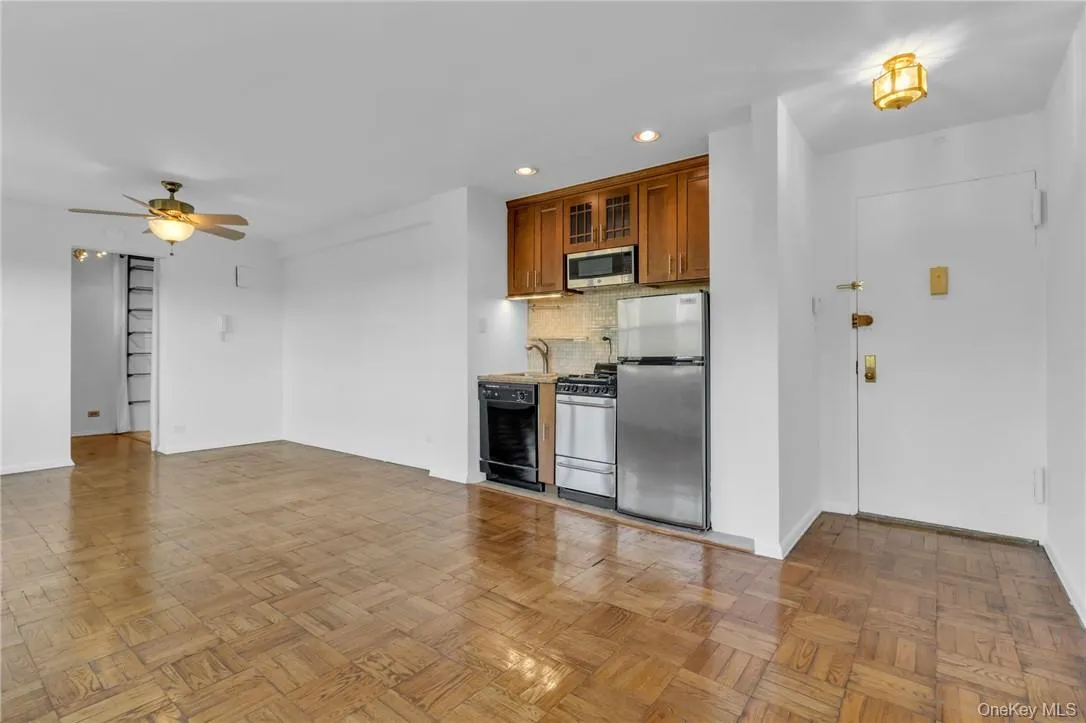 Kitchen with stainless steel appliances, sink, tasteful backsplash, ceiling fan, and light parquet flooring Kitchen with stainless steel appliances, sink, tasteful backsplash, ceiling fan, and light parquet flooring