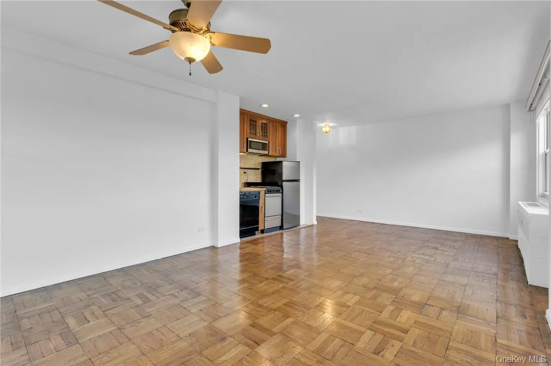 Unfurnished living room with ceiling fan and light parquet floors Unfurnished living room with ceiling fan and light parquet floors