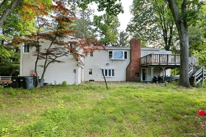 Rear view of property featuring a lawn and a deck Rear view of property featuring a lawn and a deck