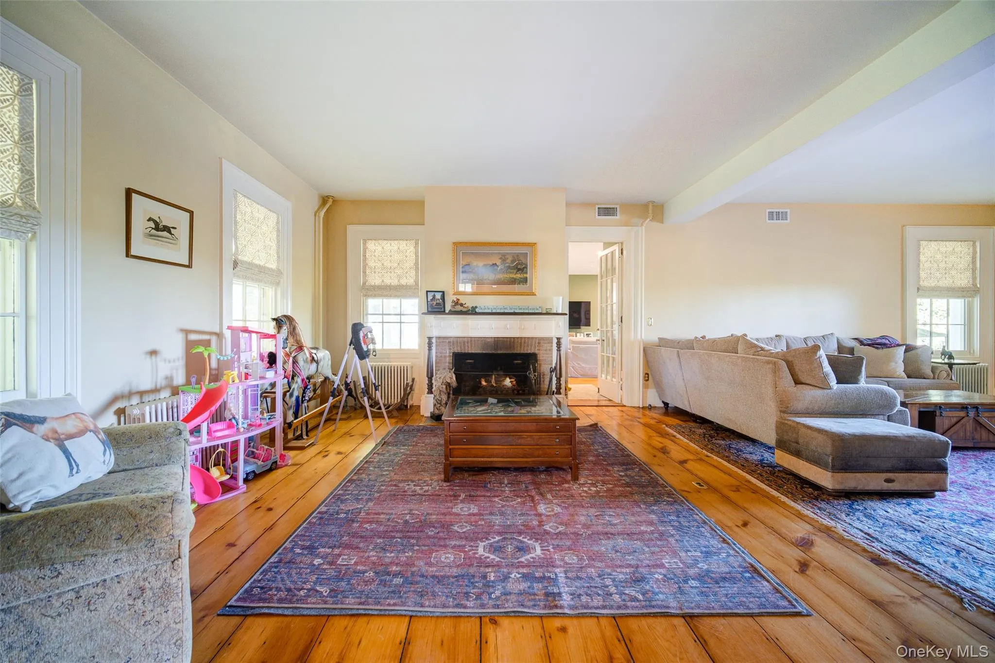 Living area with hardwood / wood-style flooring, a fireplace, and radiator Living area with hardwood / wood-style flooring, a fireplace, and radiator