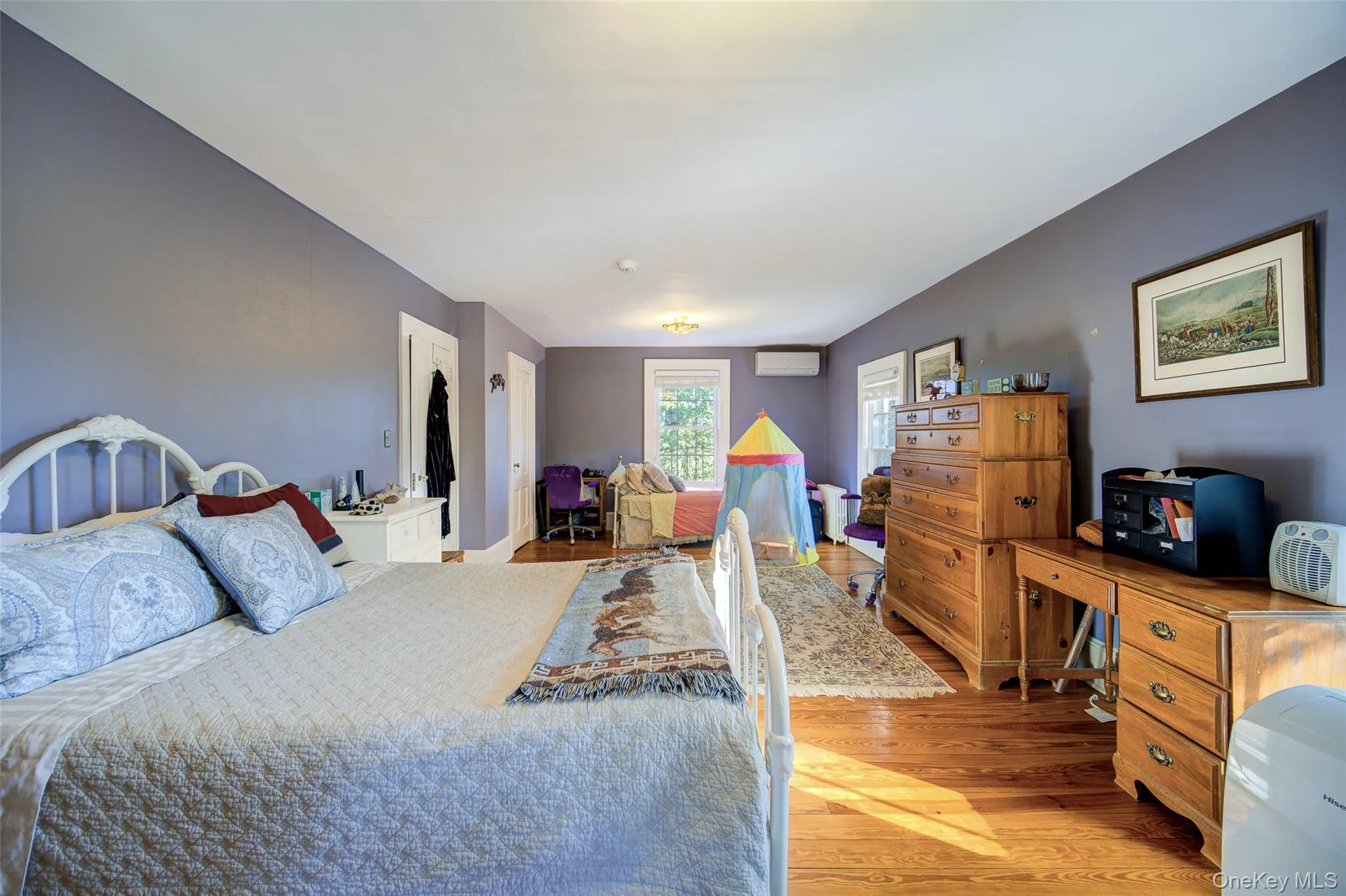 Bedroom featuring light wood-type flooring and a wall mounted AC Bedroom featuring light wood-type flooring and a wall mounted AC