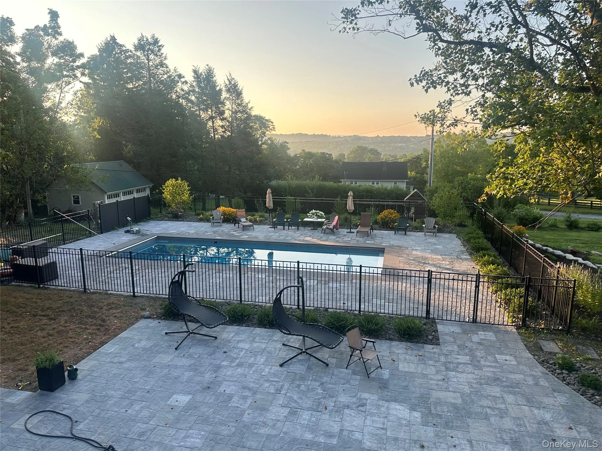 Pool at dusk featuring a patio and a community pool Pool at dusk featuring a patio and a community pool