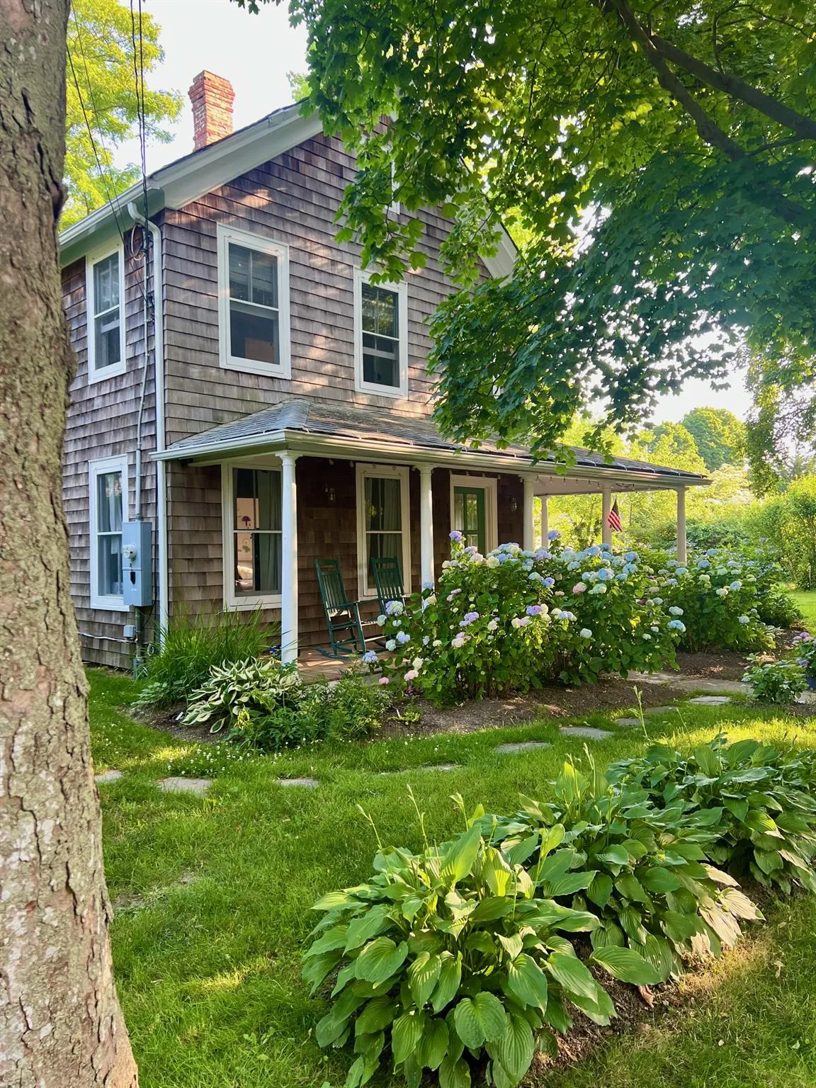View of front facade featuring a chimney and a porch View of front facade featuring a chimney and a porch