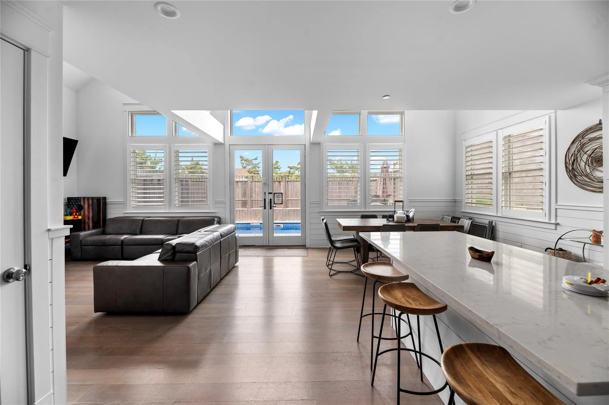 Living room with french doors, wood-type flooring, and plenty of natural light Living room with french doors, wood-type flooring, and plenty of natural light