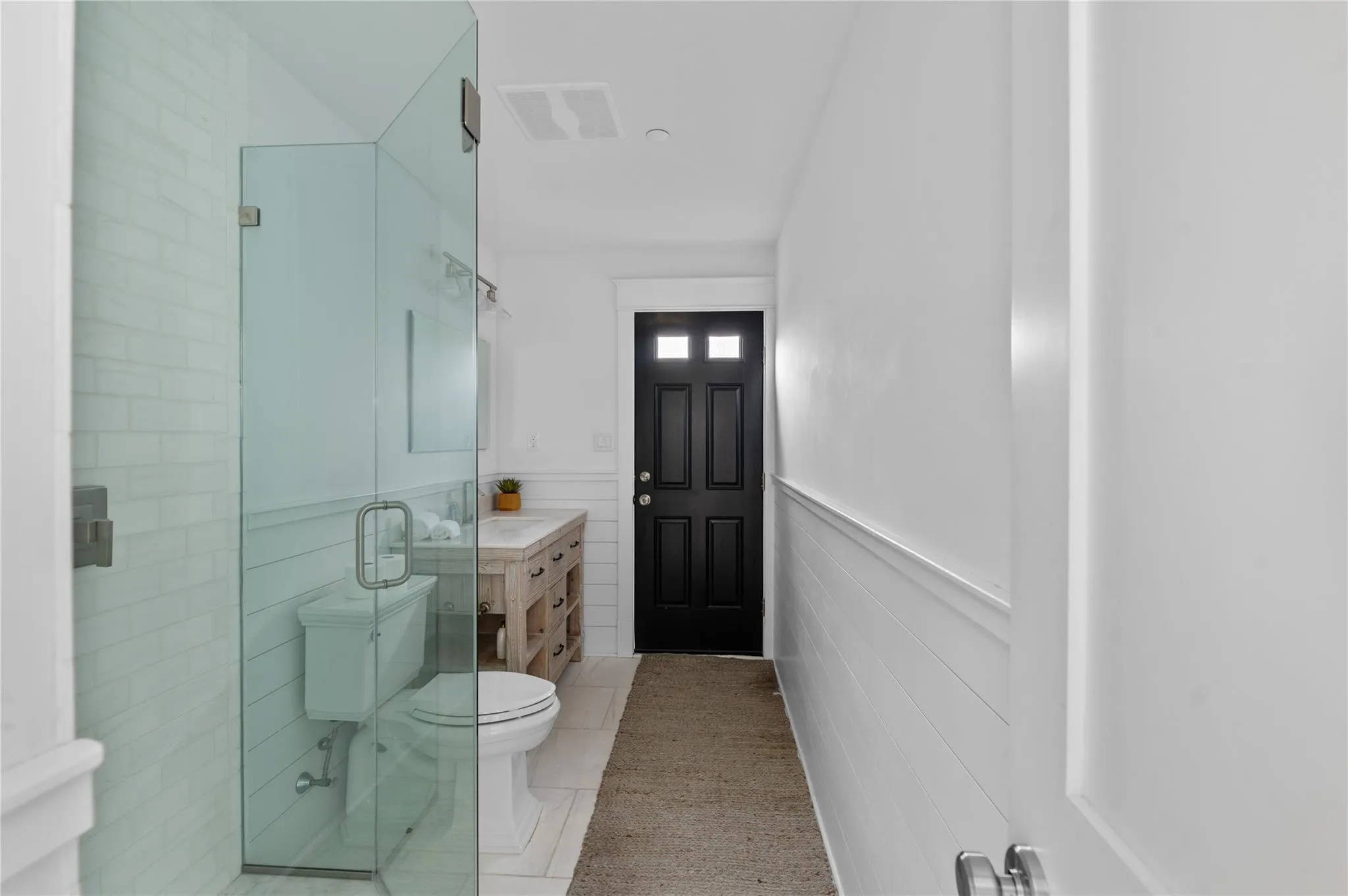 Bathroom with an enclosed shower, vanity, tile patterned floors, and toilet Bathroom with an enclosed shower, vanity, tile patterned floors, and toilet