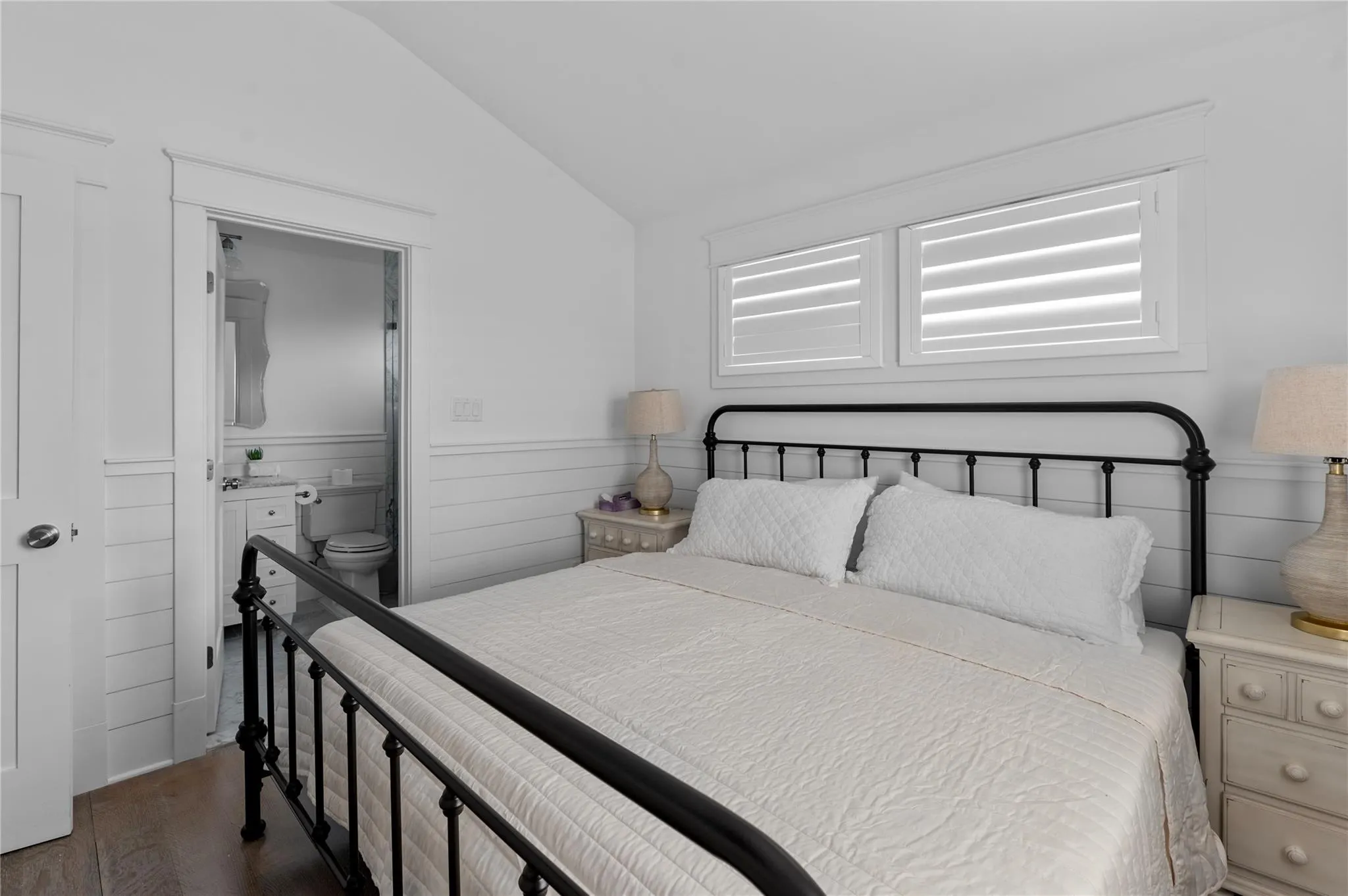 Bedroom featuring vaulted ceiling, dark hardwood / wood-style floors, and ensuite bath Bedroom featuring vaulted ceiling, dark hardwood / wood-style floors, and ensuite bath
