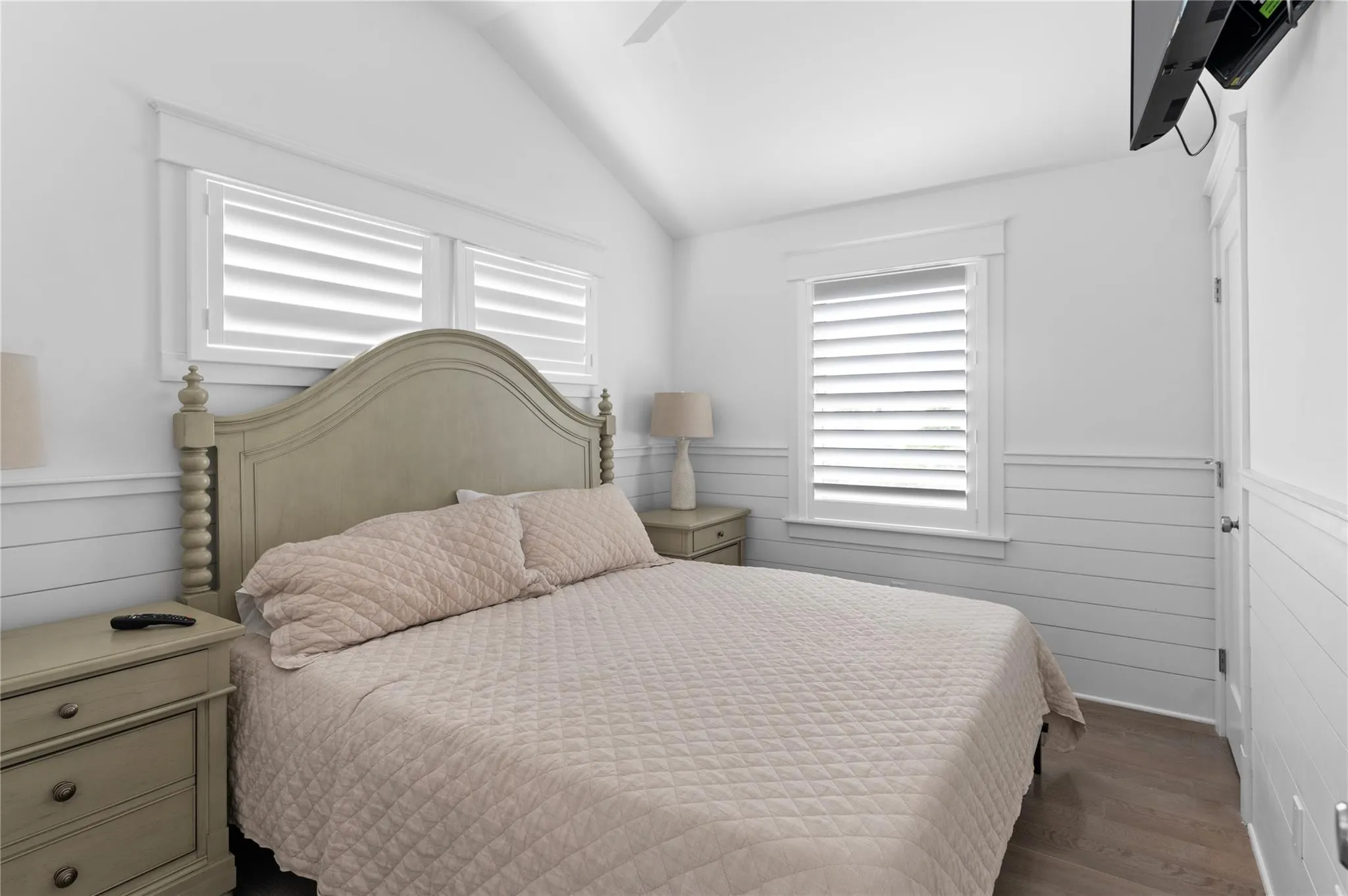 Bedroom with dark wood-type flooring, vaulted ceiling, and ceiling fan Bedroom with dark wood-type flooring, vaulted ceiling, and ceiling fan
