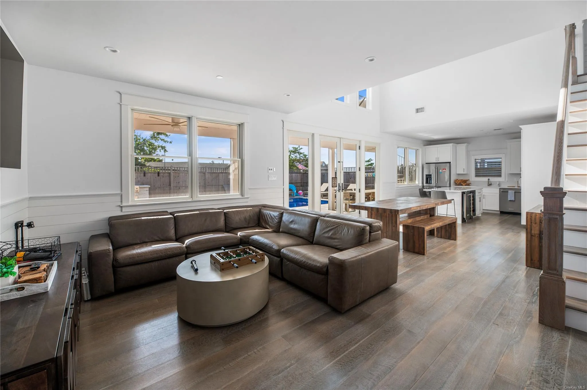 Living room with hardwood / wood-style floors, a towering ceiling, and french doors Living room with hardwood / wood-style floors, a towering ceiling, and french doors