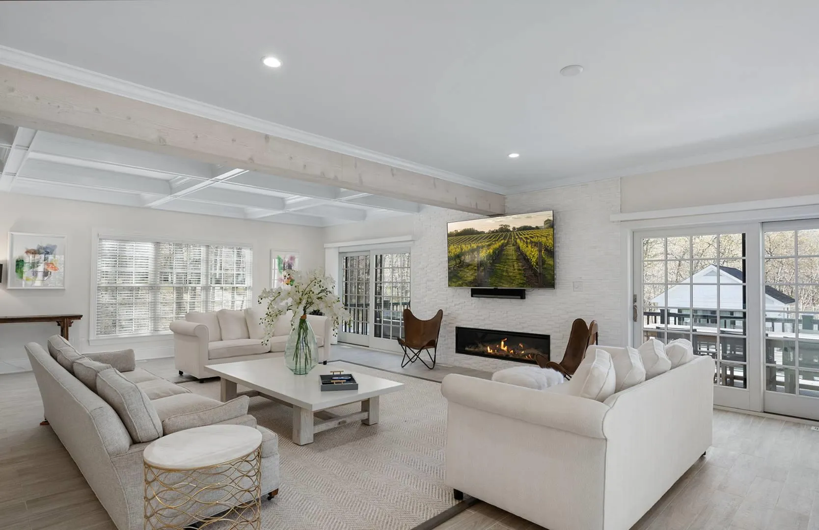 Living room featuring coffered ceiling, light wood-style floors, a fireplace, beam ceiling, and recessed lighting Living room featuring coffered ceiling, light wood-style floors, a fireplace, beam ceiling, and recessed lighting
