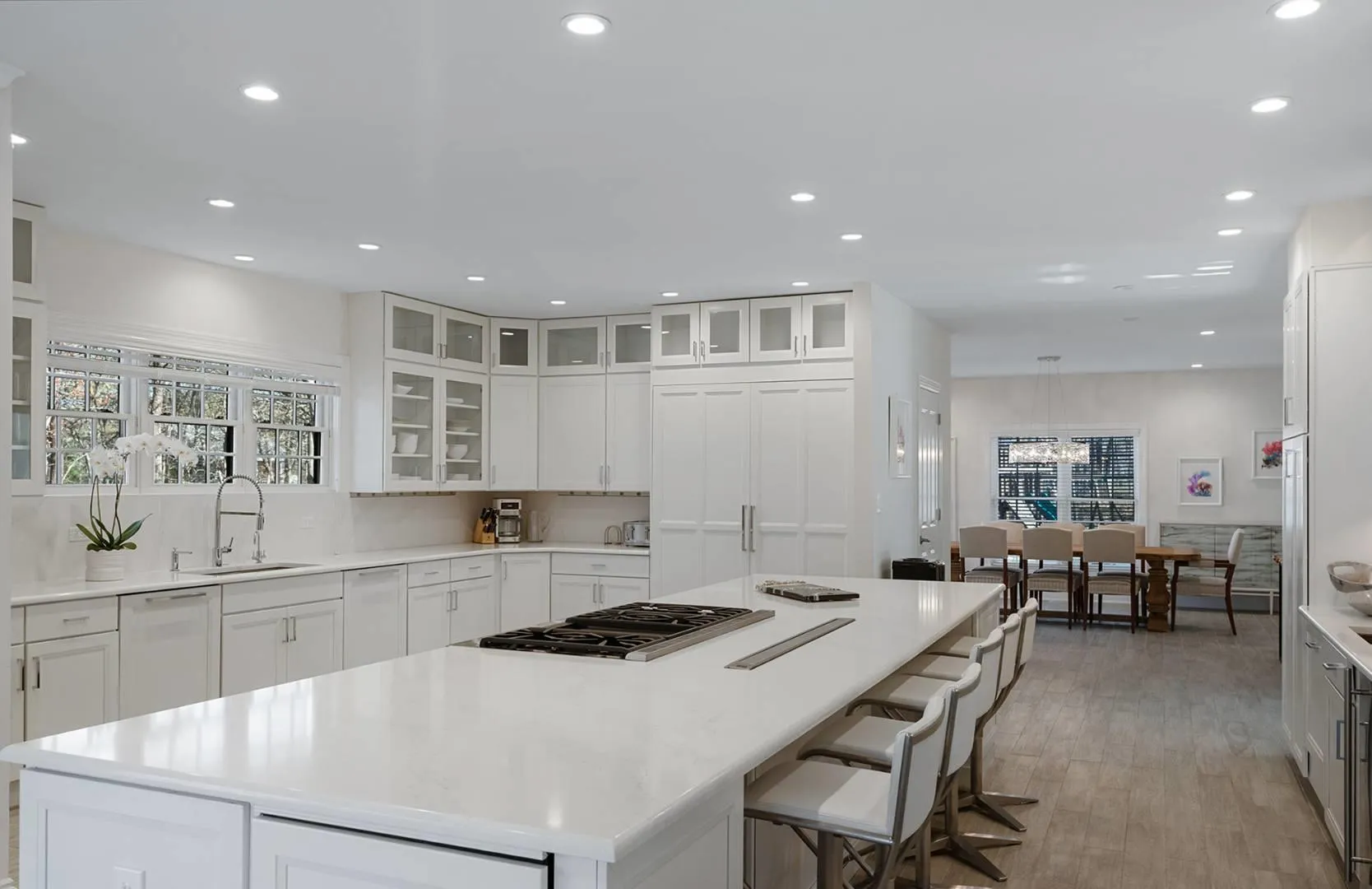 Kitchen with white dishwasher, a center island, stainless steel gas stovetop, recessed lighting, and white cabinets Kitchen with white dishwasher, a center island, stainless steel gas stovetop, recessed lighting, and white cabinets