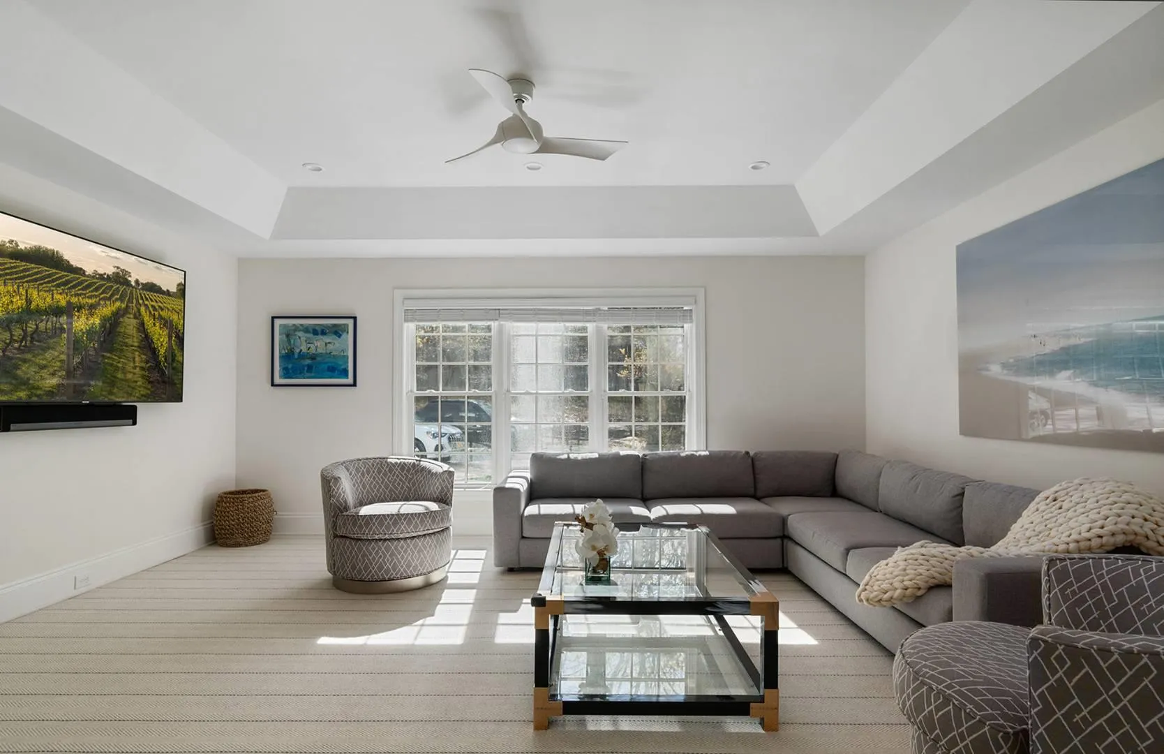 Living room featuring a tray ceiling and a ceiling fan Living room featuring a tray ceiling and a ceiling fan