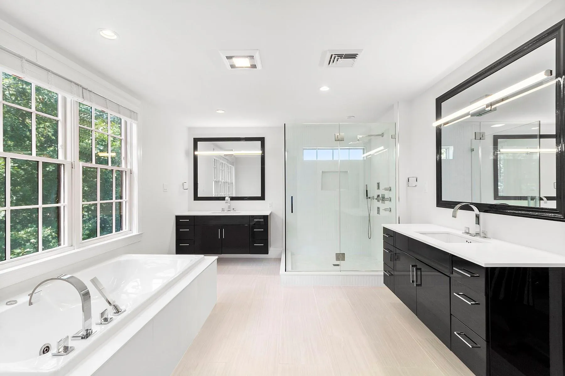 Full bathroom featuring a stall shower, two vanities, a garden tub, recessed lighting, and wood finished floors Full bathroom featuring a stall shower, two vanities, a garden tub, recessed lighting, and wood finished floors