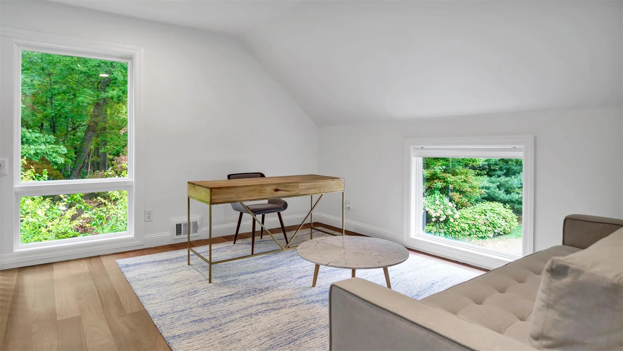 Office space with light hardwood / wood-style flooring and lofted ceiling Office space with light hardwood / wood-style flooring and lofted ceiling