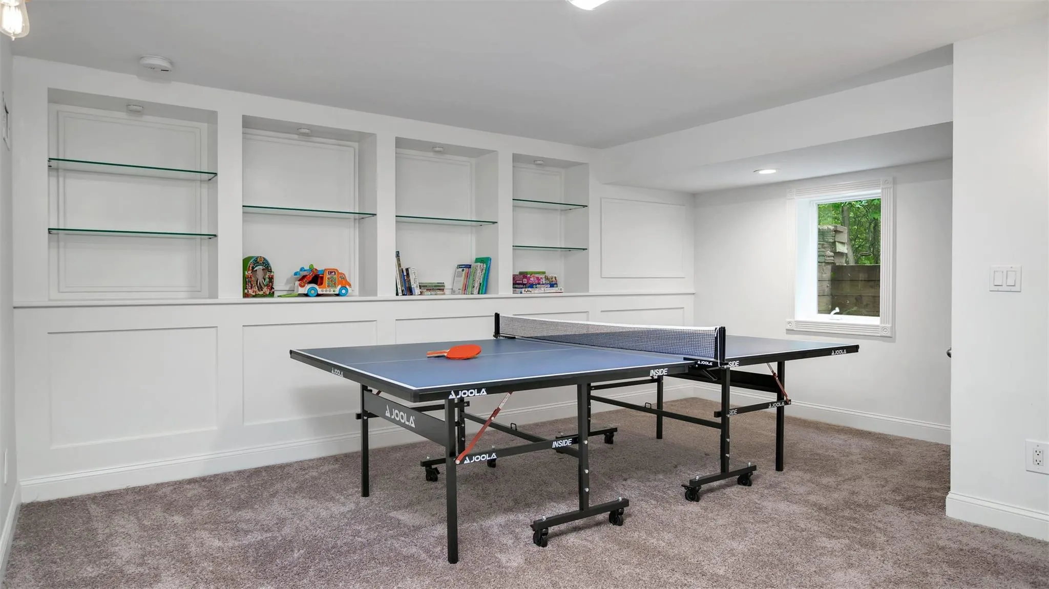 Recreation room with carpet flooring and built in features Recreation room with carpet flooring and built in features