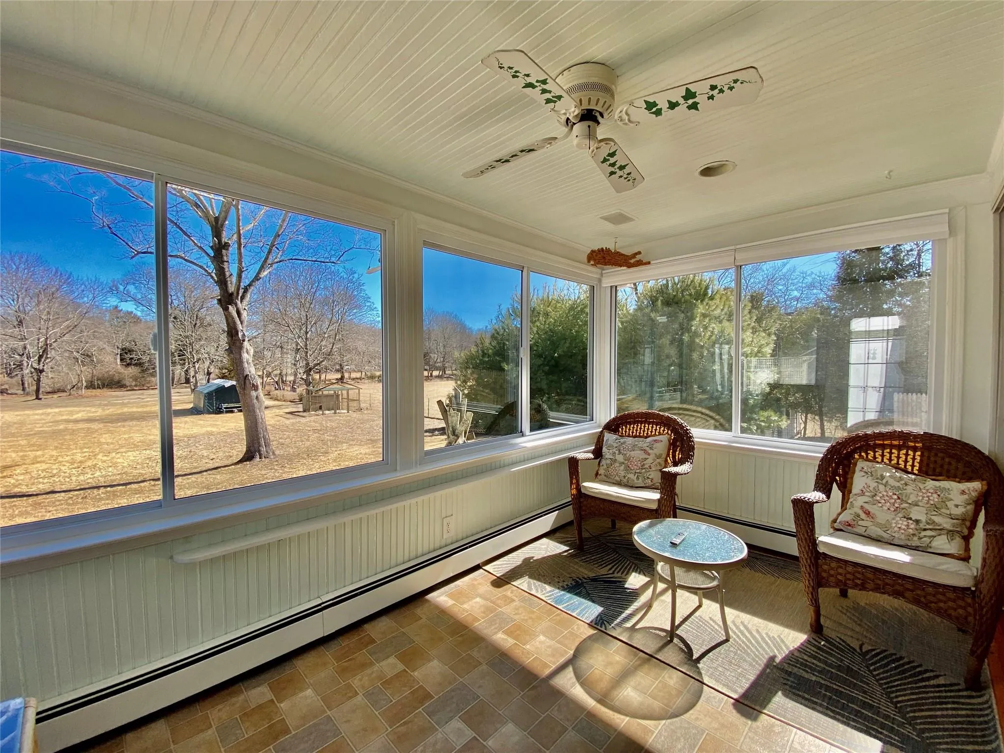 Sunroom featuring ceiling fan and baseboard heating Sunroom featuring ceiling fan and baseboard heating