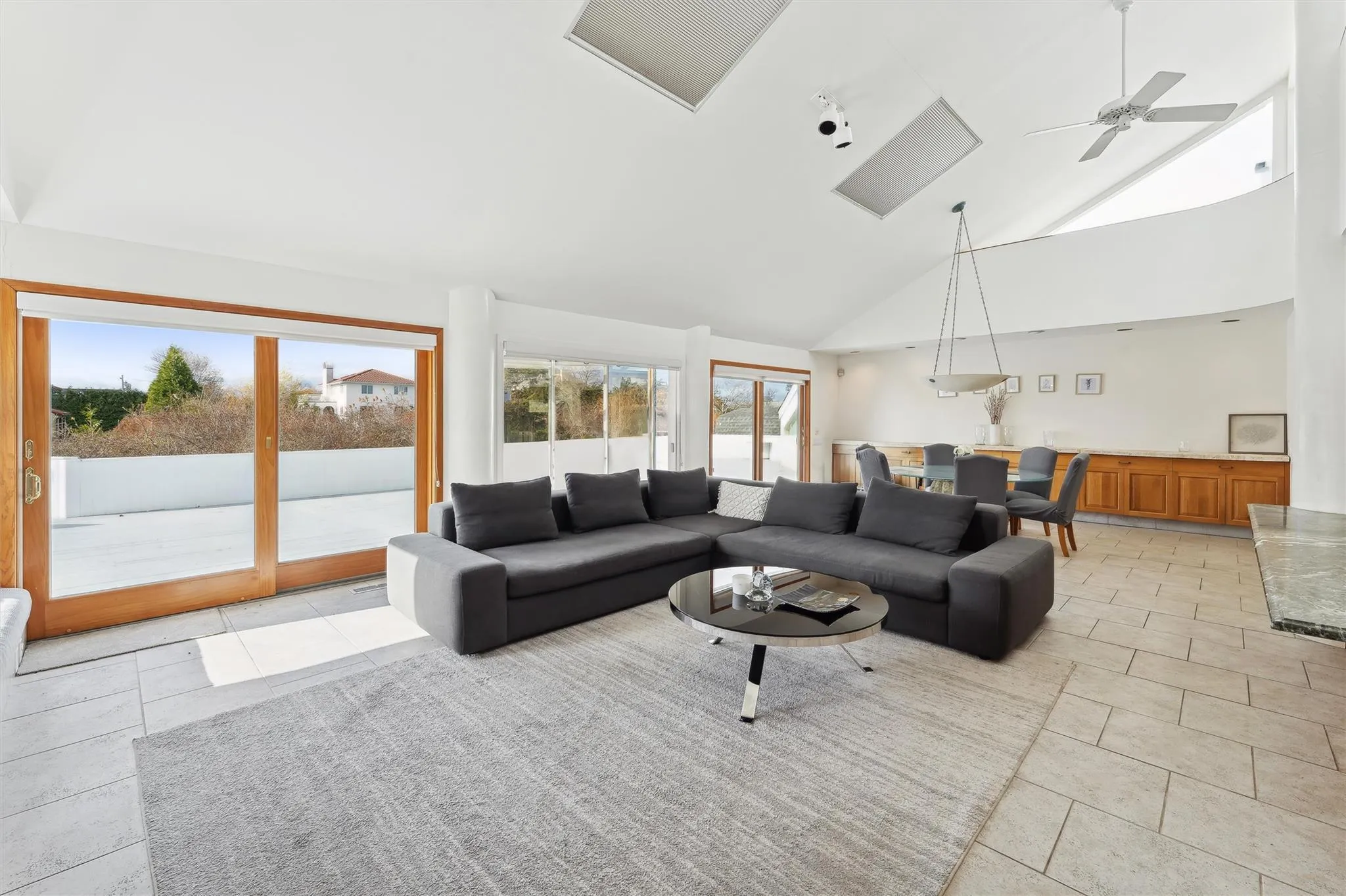 Living room with high vaulted ceiling, ceiling fan, and a healthy amount of sunlight Living room with high vaulted ceiling, ceiling fan, and a healthy amount of sunlight