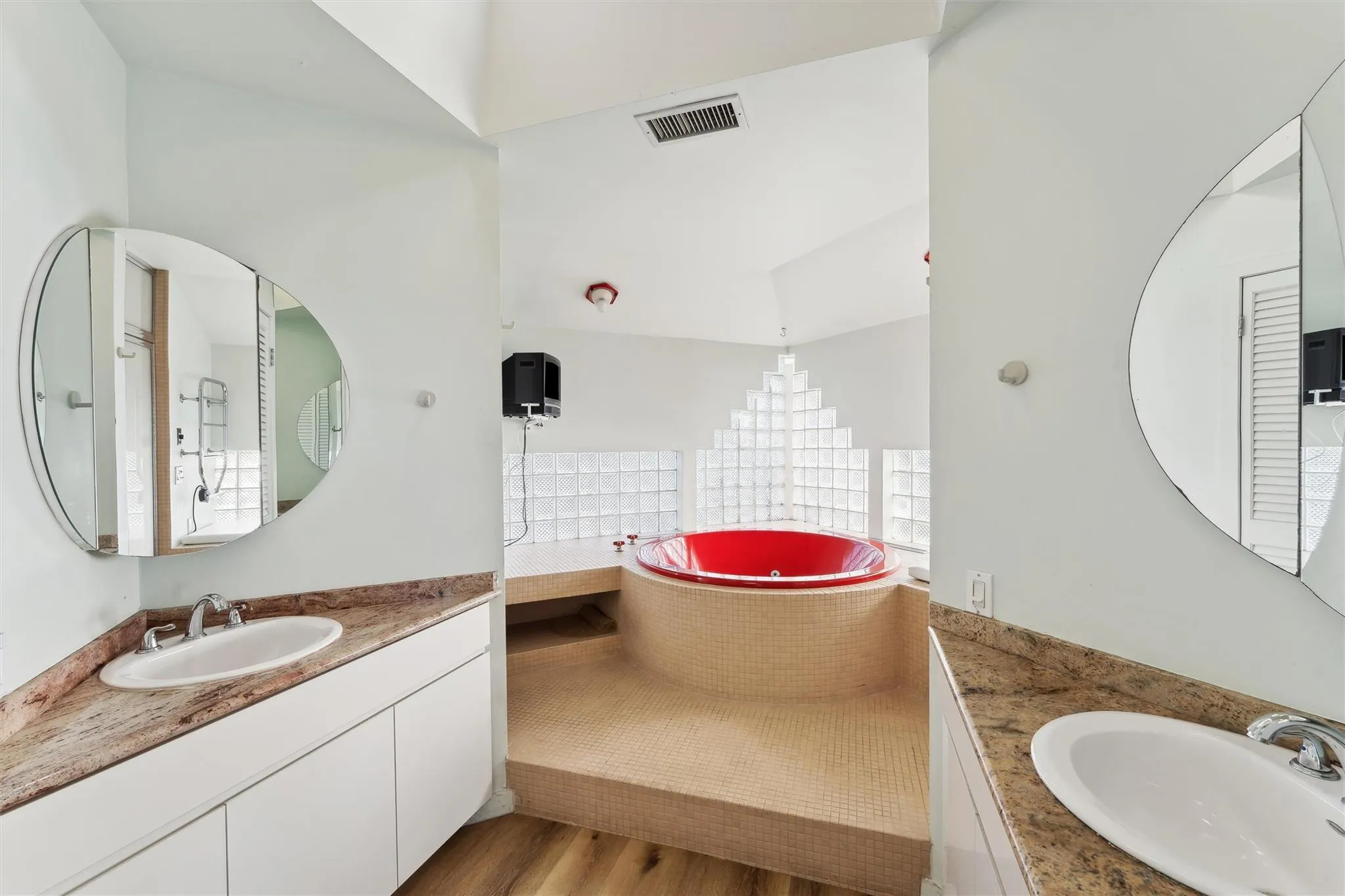 Bathroom with hardwood / wood-style floors, vanity, plenty of natural light, and a washtub Bathroom with hardwood / wood-style floors, vanity, plenty of natural light, and a washtub