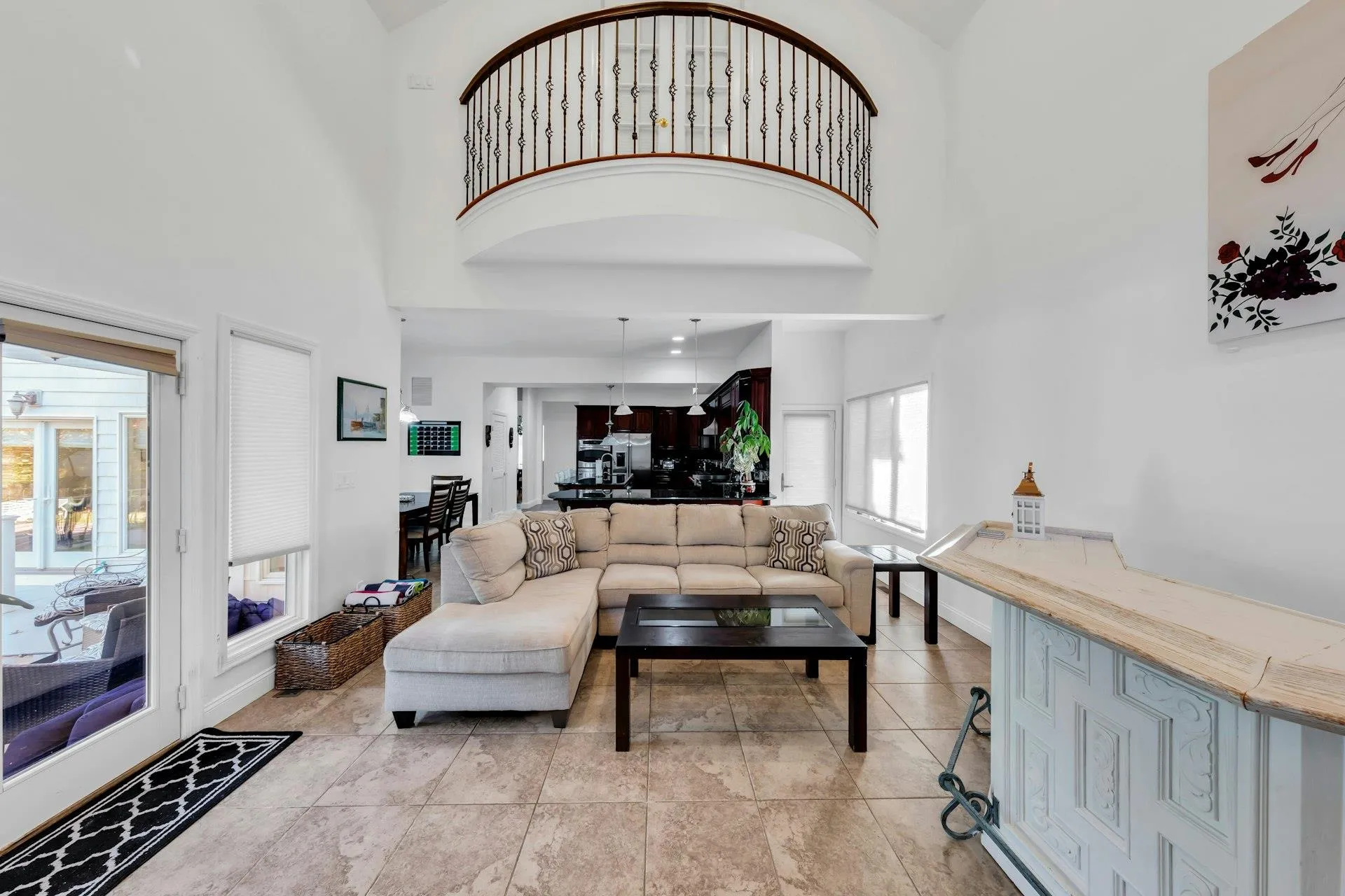 Living area featuring a towering ceiling and light tile patterned floors Living area featuring a towering ceiling and light tile patterned floors