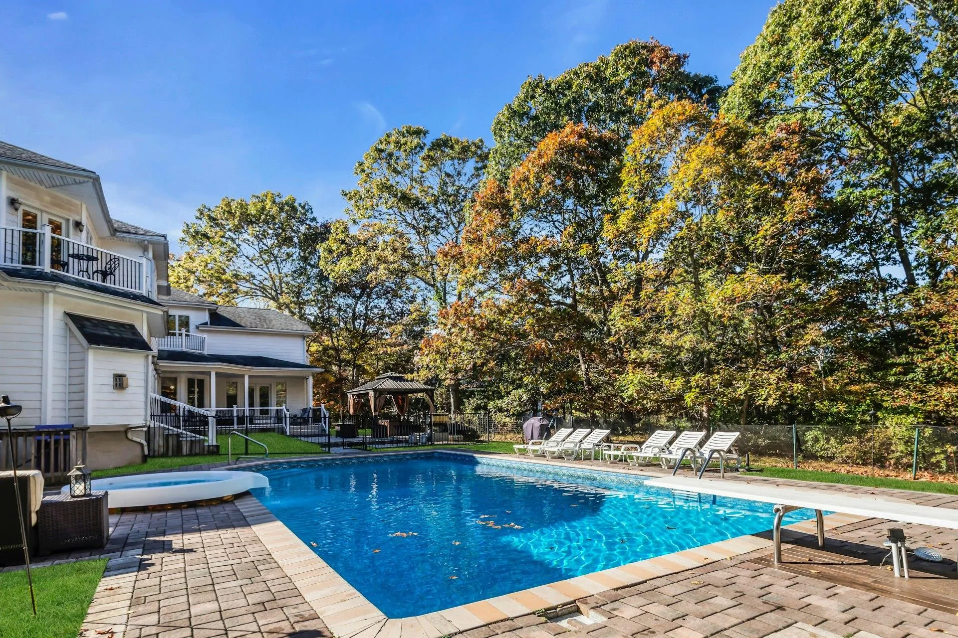 View of pool with a patio, a balcony, a gazebo, a diving board, and a pool with connected hot tub View of pool with a patio, a balcony, a gazebo, a diving board, and a pool with connected hot tub