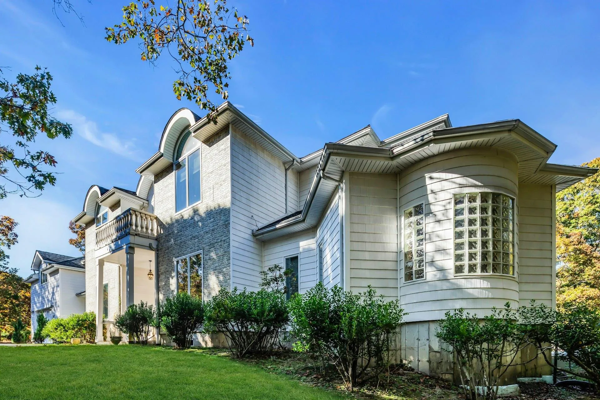 View of property exterior featuring a balcony and a yard View of property exterior featuring a balcony and a yard