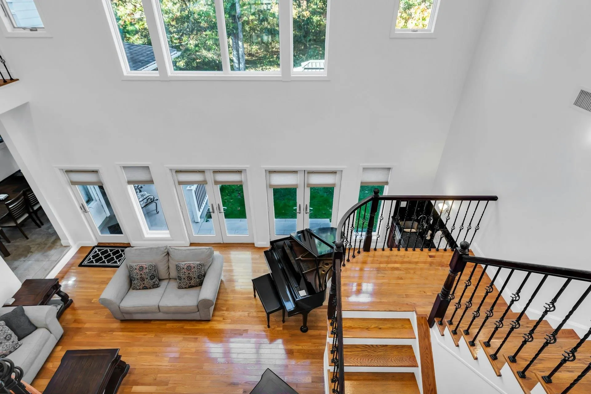 Living room with a high ceiling, french doors, hardwood / wood-style flooring, and stairs Living room with a high ceiling, french doors, hardwood / wood-style flooring, and stairs
