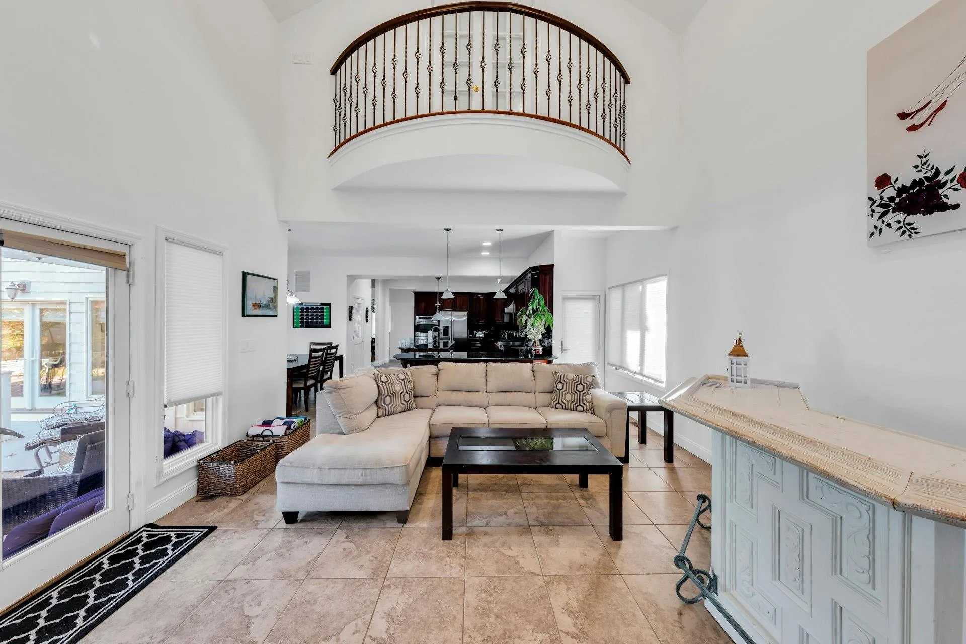 Living area featuring a towering ceiling and light tile patterned flooring Living area featuring a towering ceiling and light tile patterned flooring