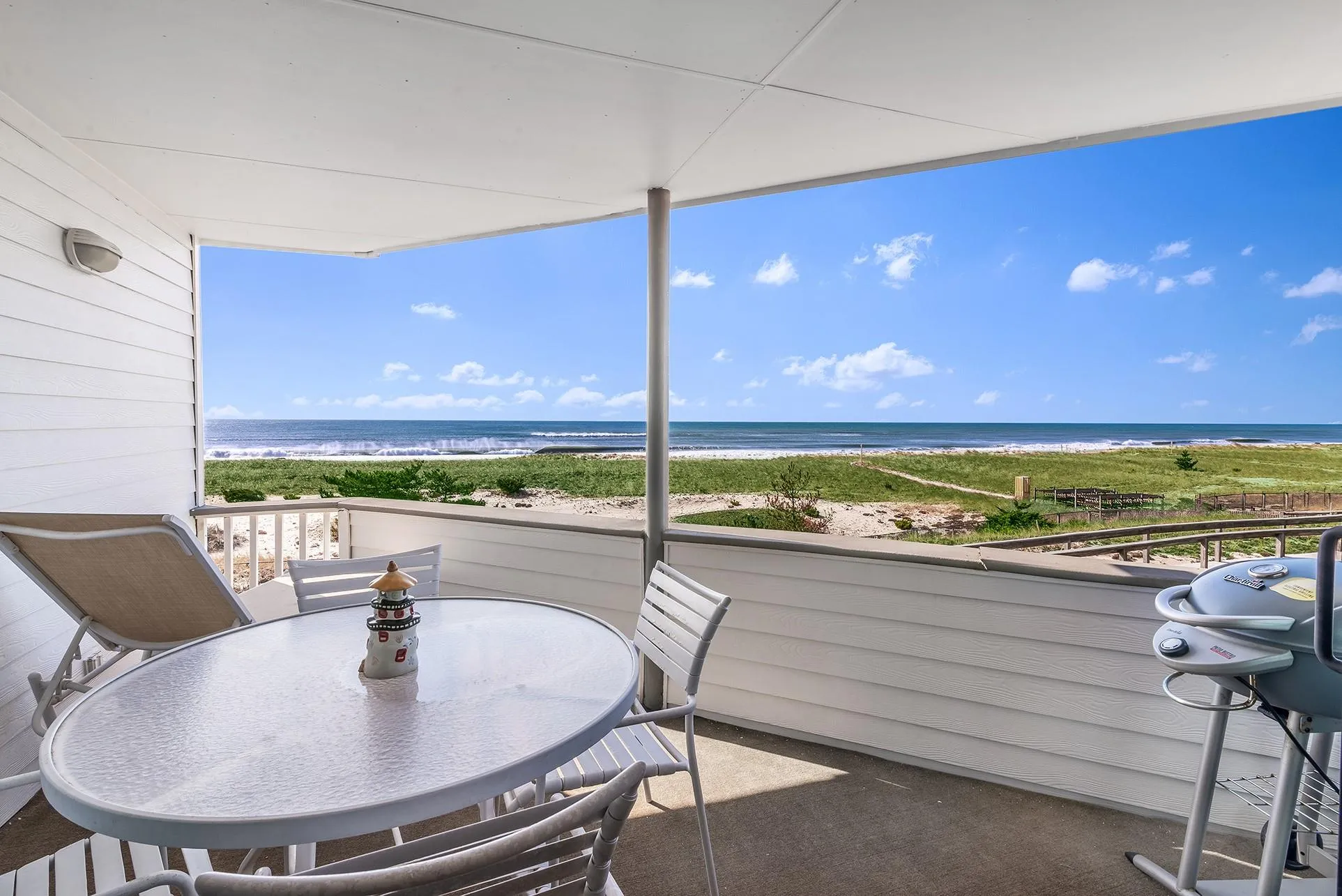 Balcony featuring a water view, a beach view, and outdoor dining space Balcony featuring a water view, a beach view, and outdoor dining space