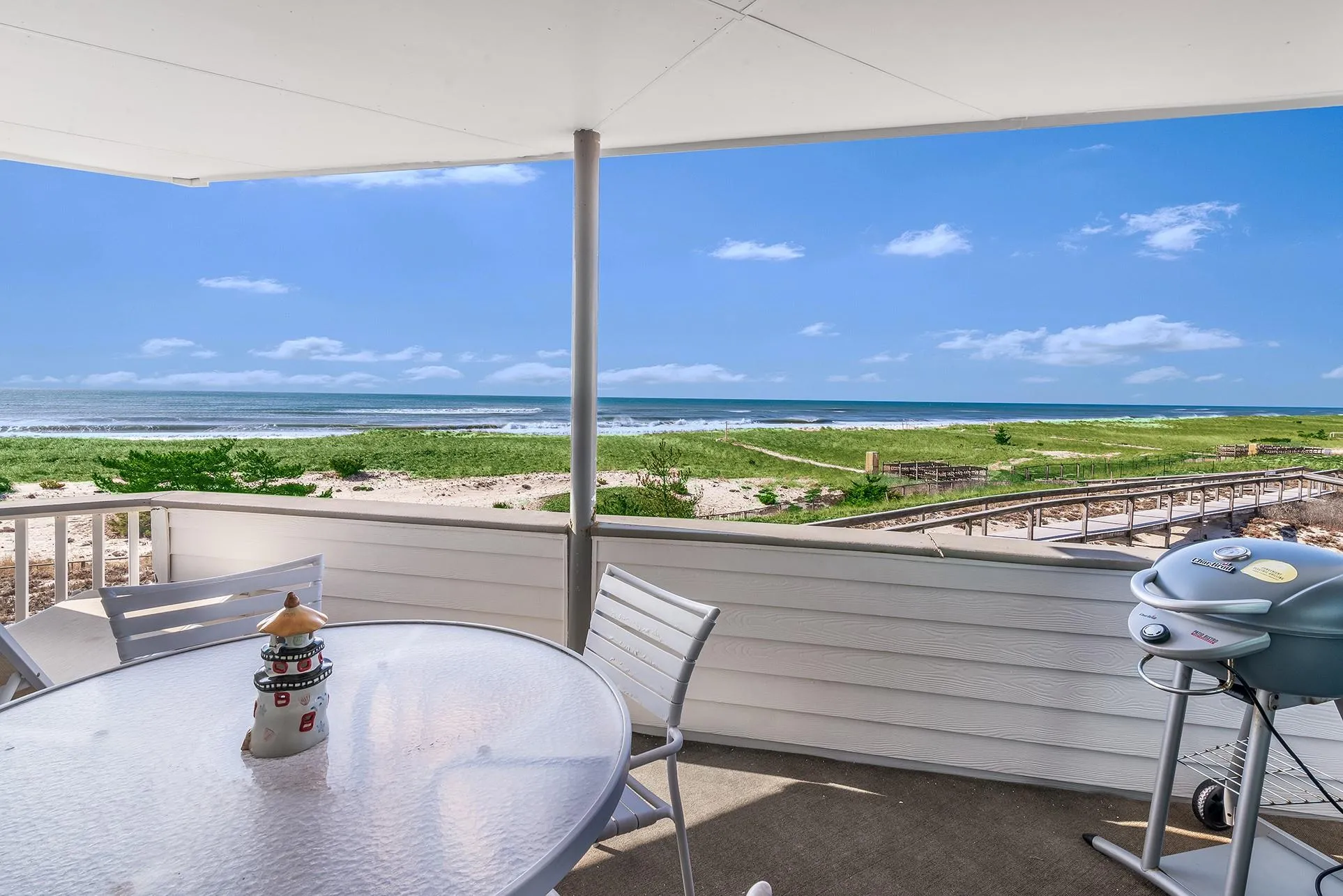 Balcony featuring a water view, a view of the beach, and area for grilling Balcony featuring a water view, a view of the beach, and area for grilling