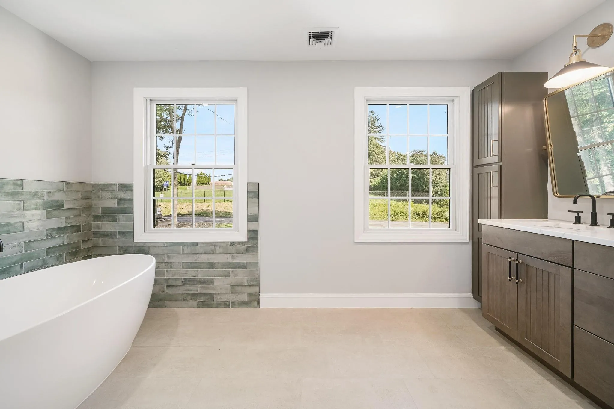 Bathroom featuring a tub to relax in, vanity, tile patterned flooring, and tile walls Bathroom featuring a tub to relax in, vanity, tile patterned flooring, and tile walls