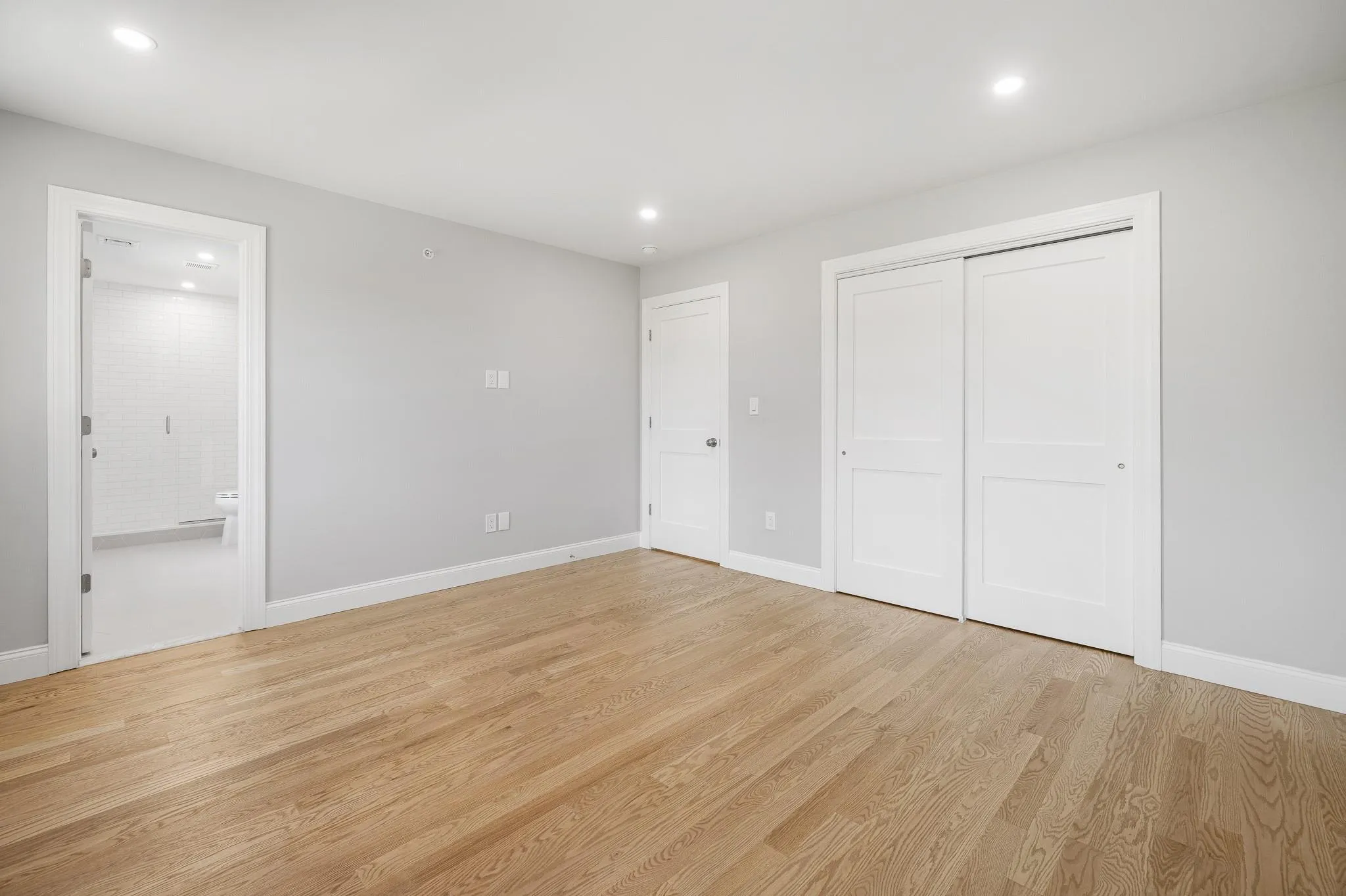Unfurnished bedroom featuring connected bathroom, light hardwood / wood-style floors, and a closet Unfurnished bedroom featuring connected bathroom, light hardwood / wood-style floors, and a closet