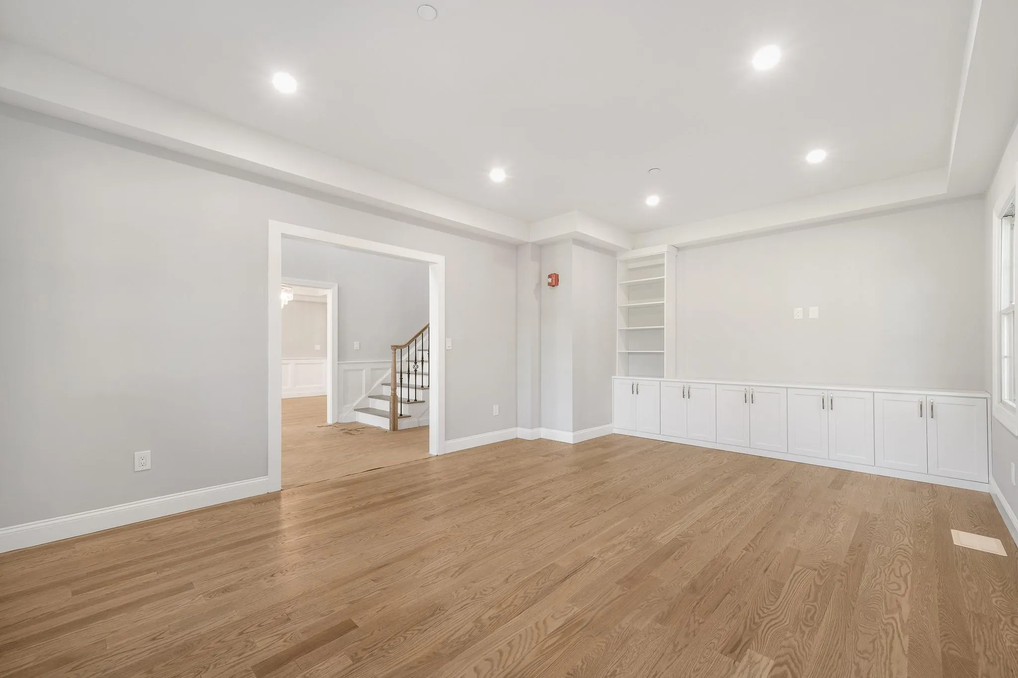 Empty room featuring built in shelves and light hardwood / wood-style floors Empty room featuring built in shelves and light hardwood / wood-style floors