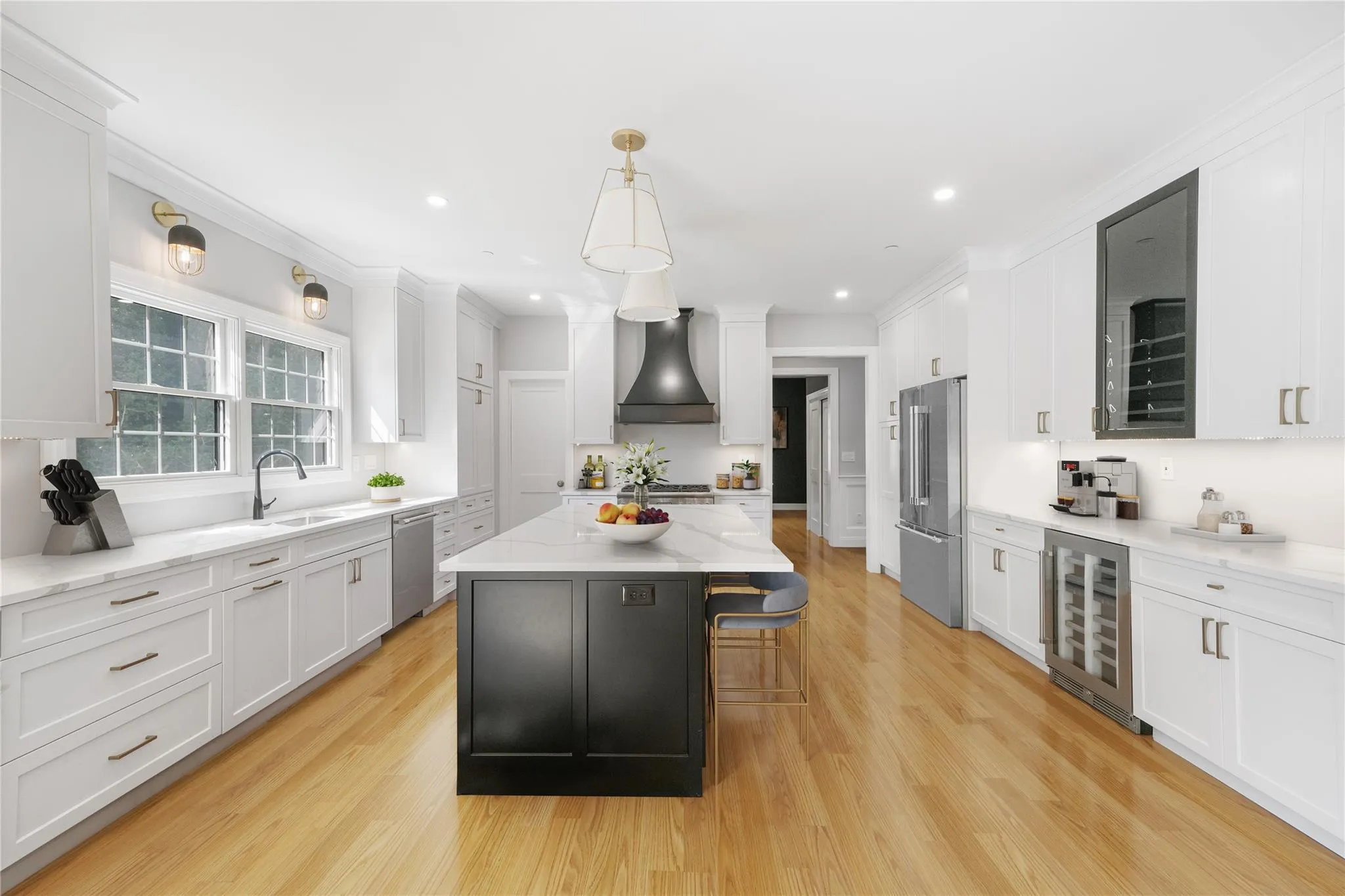 Kitchen featuring a kitchen island, appliances with stainless steel finishes, pendant lighting, beverage cooler, and custom range hood Kitchen featuring a kitchen island, appliances with stainless steel finishes, pendant lighting, beverage cooler, and custom range hood