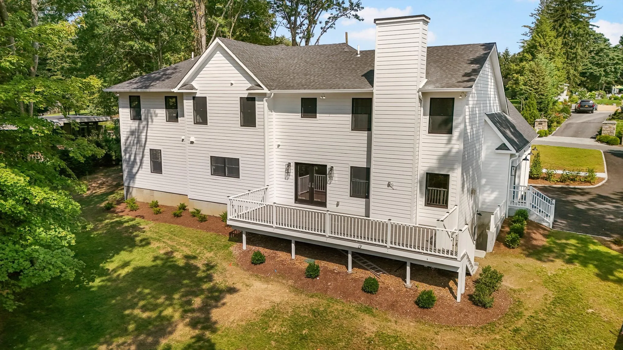 Back of property featuring a wooden deck and a lawn Back of property featuring a wooden deck and a lawn