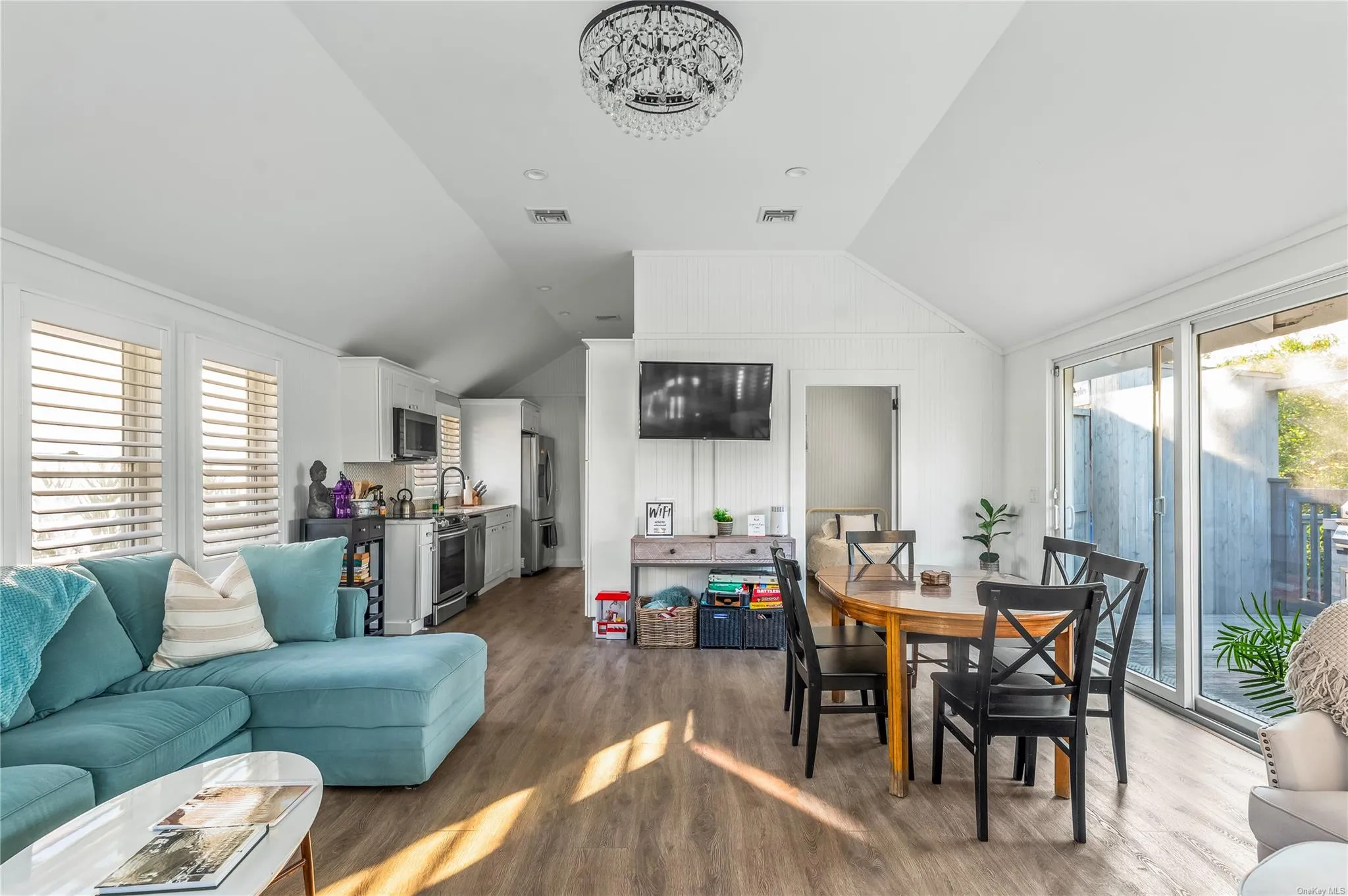 Living room featuring hardwood / wood-style flooring, lofted ceiling, and sink Living room featuring hardwood / wood-style flooring, lofted ceiling, and sink