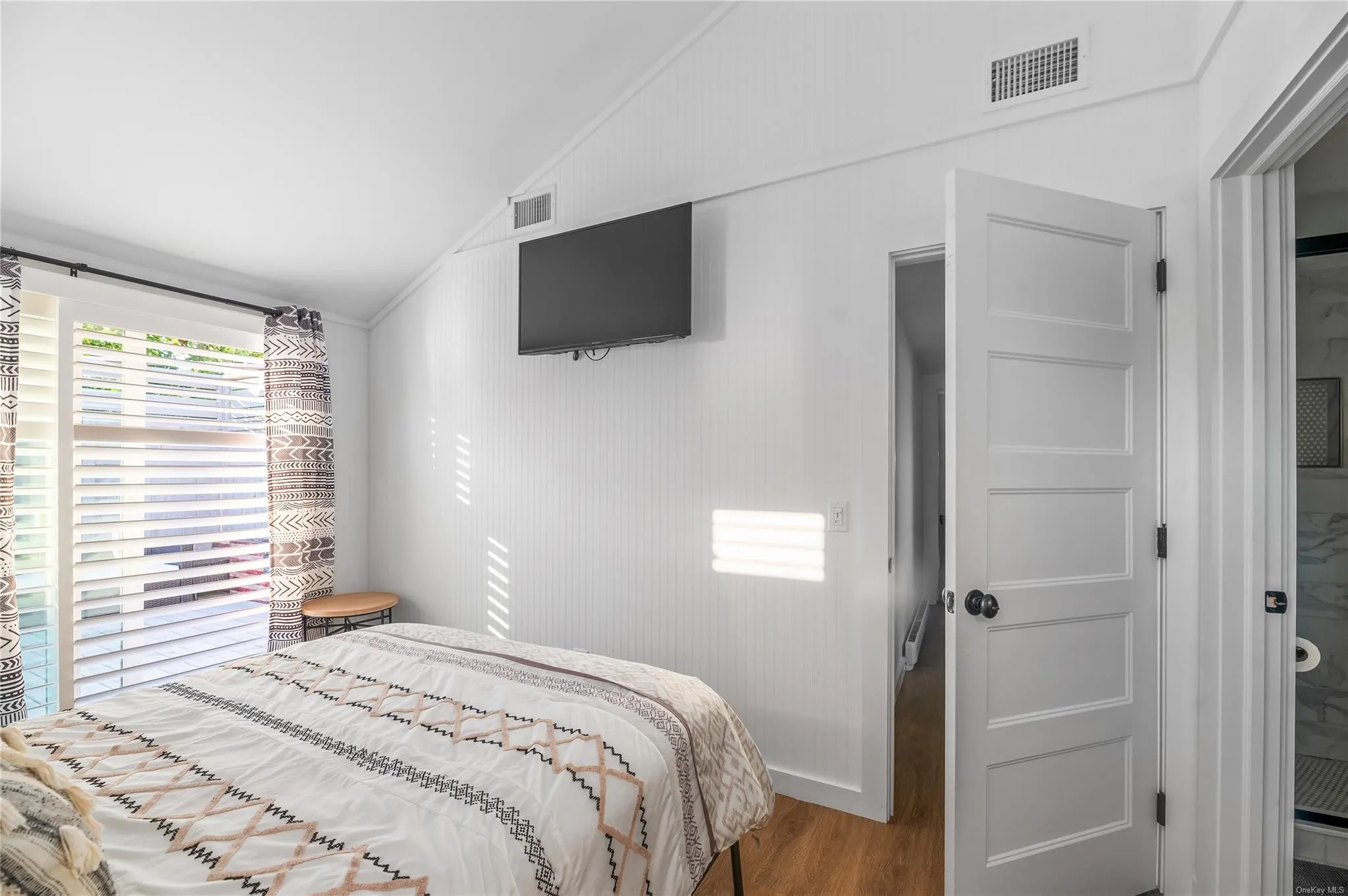 Bedroom with hardwood / wood-style flooring and lofted ceiling Bedroom with hardwood / wood-style flooring and lofted ceiling