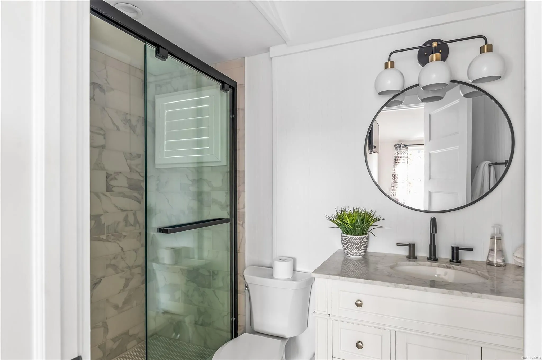 Bathroom featuring vanity, a shower with shower door, and toilet Bathroom featuring vanity, a shower with shower door, and toilet