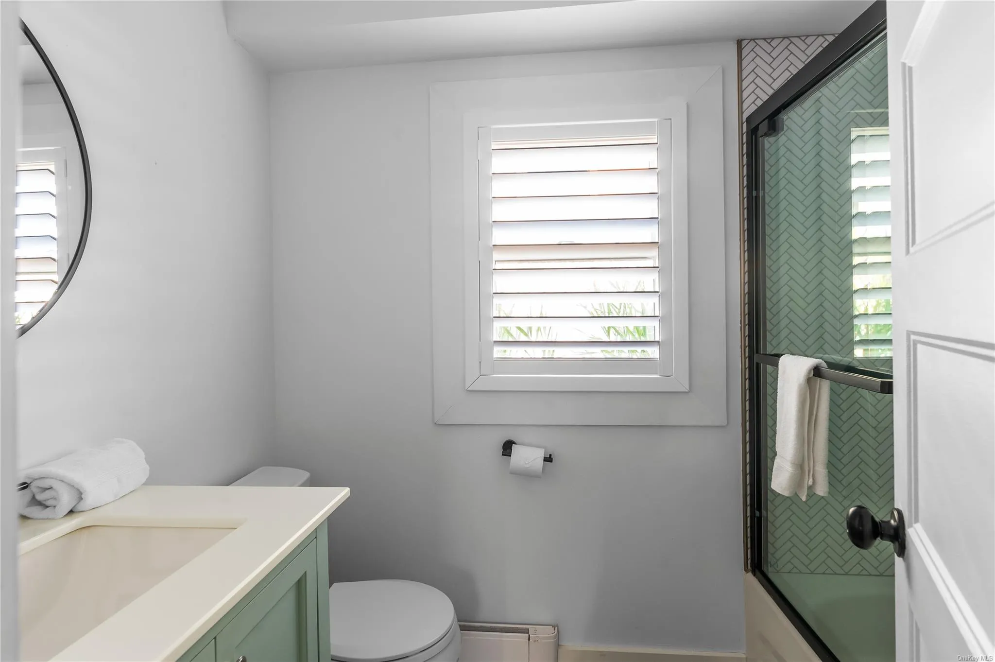 Full bathroom featuring vanity, shower / bath combination with glass door, and toilet Full bathroom featuring vanity, shower / bath combination with glass door, and toilet