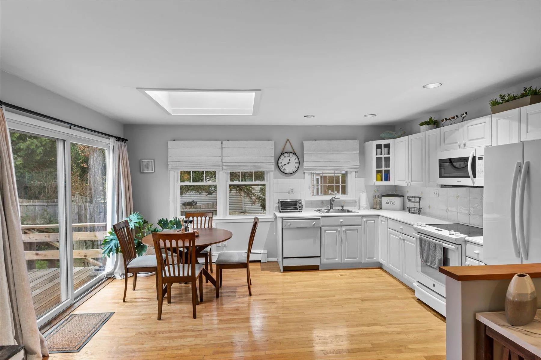 Kitchen featuring decorative backsplash, light countertops, white appliances, and a sink Kitchen featuring decorative backsplash, light countertops, white appliances, and a sink