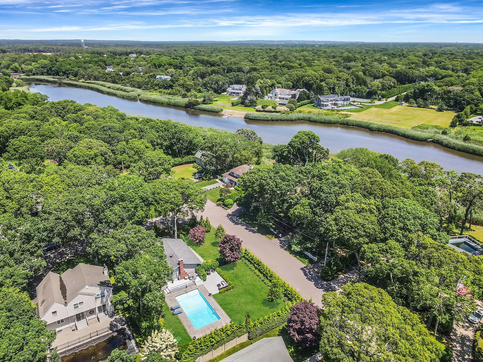 Drone / aerial view of a forest and a nearby body of water Drone / aerial view of a forest and a nearby body of water