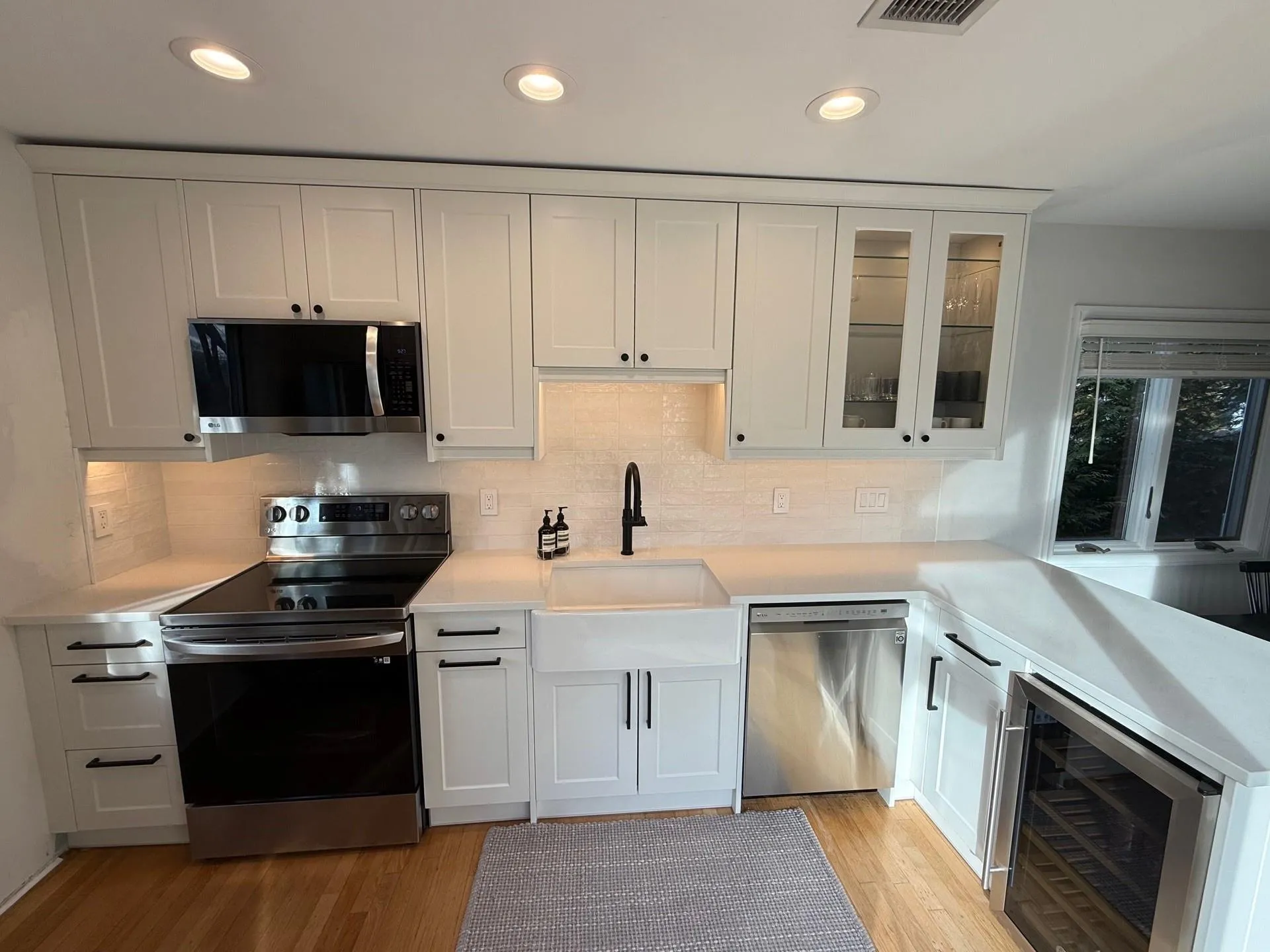 Kitchen with white cabinets, appliances with stainless steel finishes, beverage cooler, and sink Kitchen with white cabinets, appliances with stainless steel finishes, beverage cooler, and sink