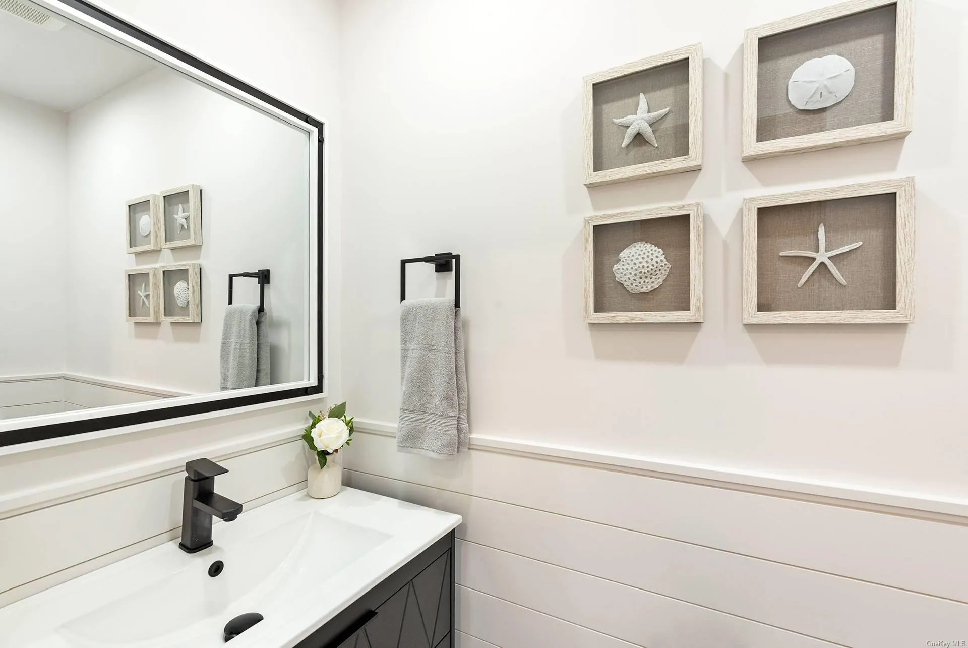 Bathroom with a wainscoted wall and vanity Bathroom with a wainscoted wall and vanity