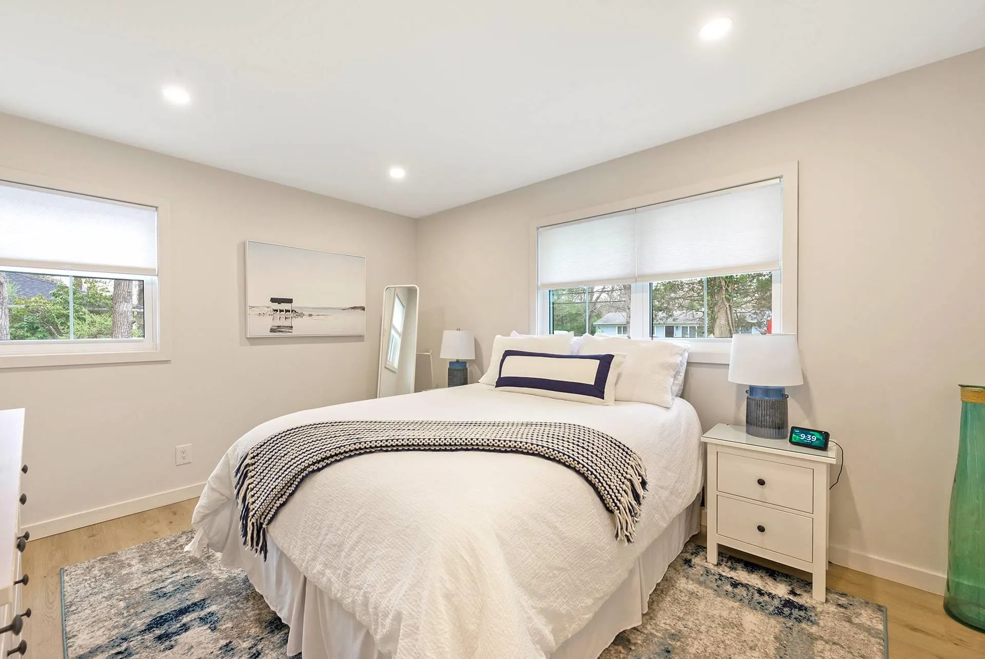 Bedroom with multiple windows, light wood-style floors, recessed lighting, and baseboards Bedroom with multiple windows, light wood-style floors, recessed lighting, and baseboards