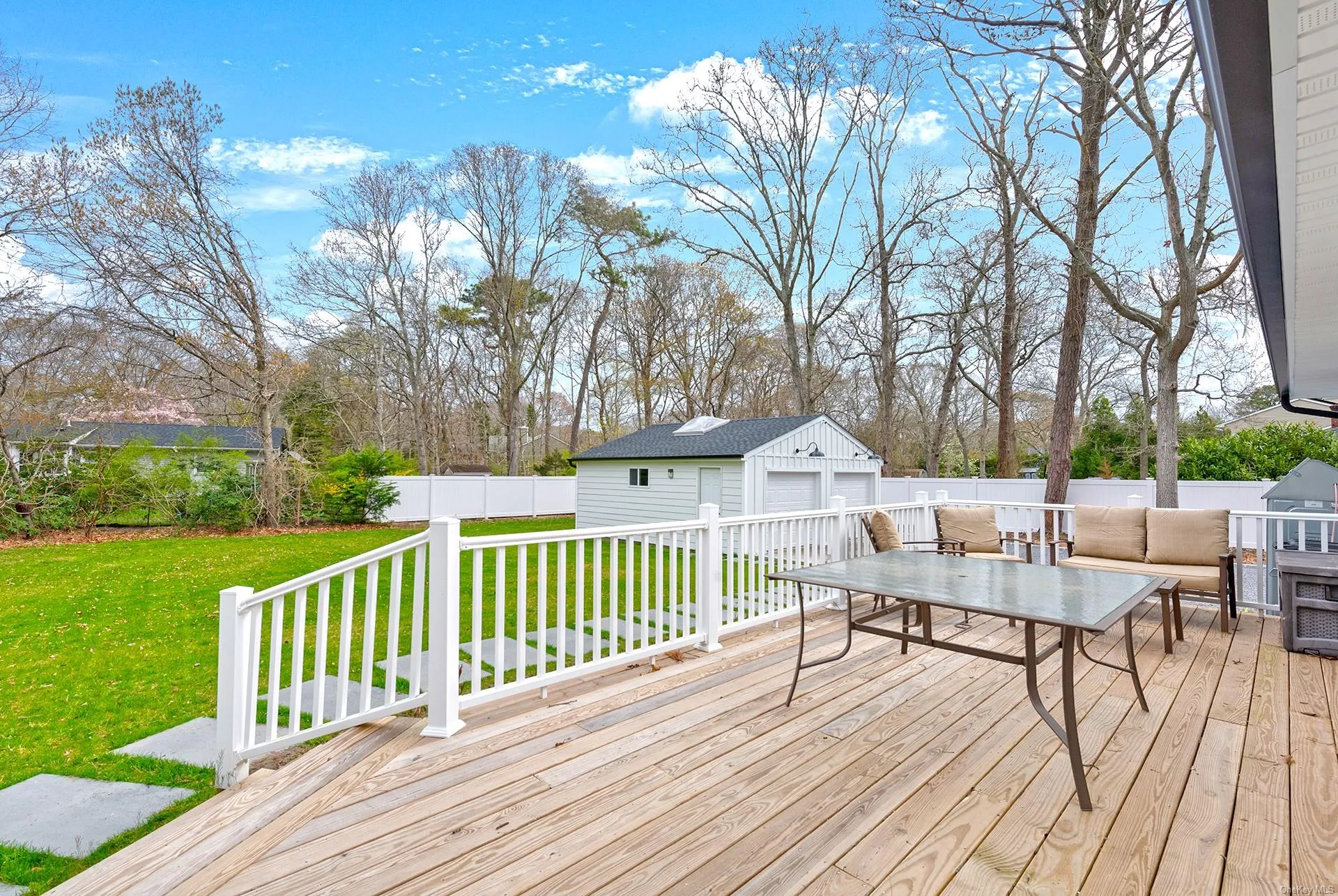 Wooden terrace featuring an outdoor structure, a garage, and outdoor lounge area Wooden terrace featuring an outdoor structure, a garage, and outdoor lounge area