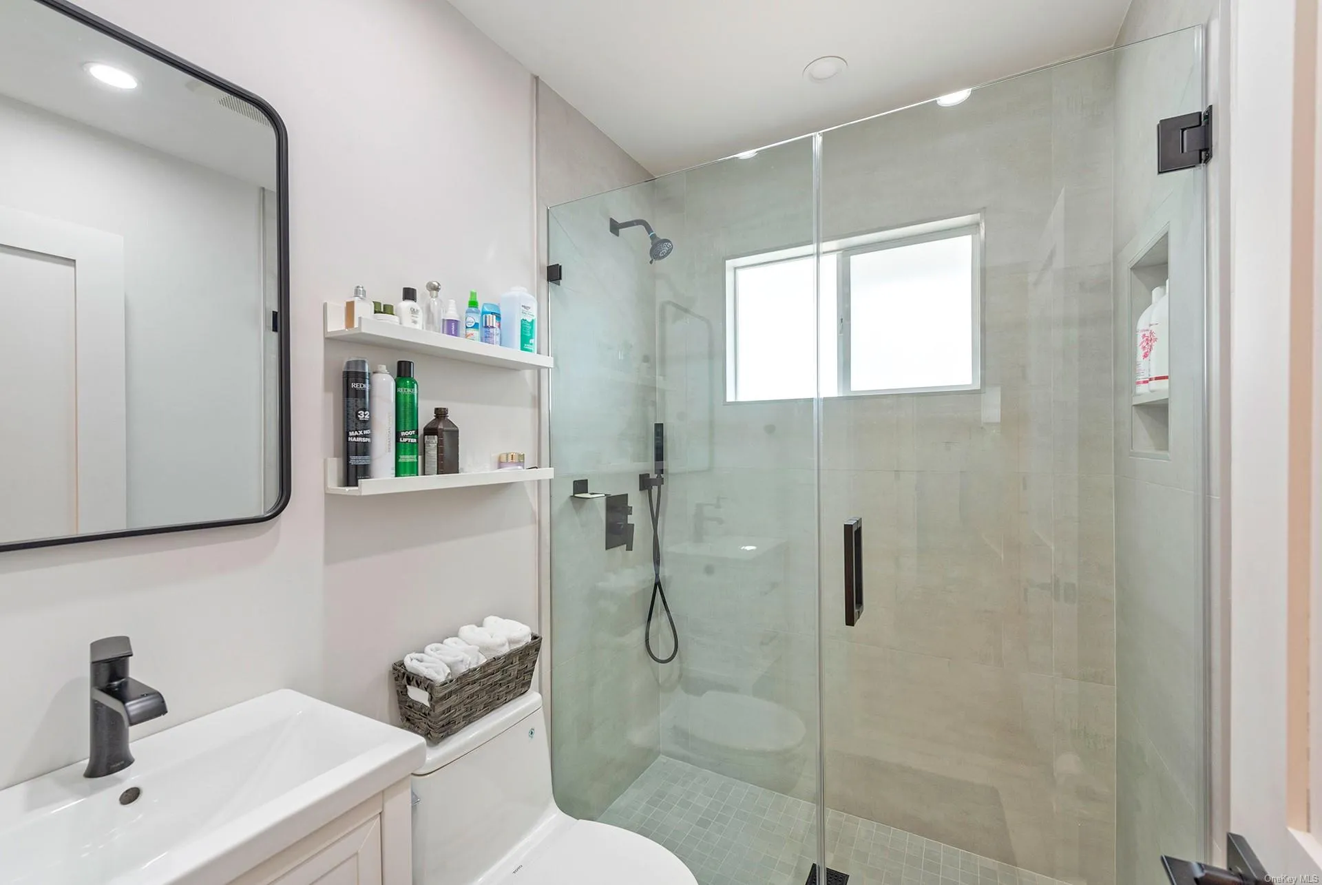 Bathroom with toilet, a stall shower, and a sink Bathroom with toilet, a stall shower, and a sink