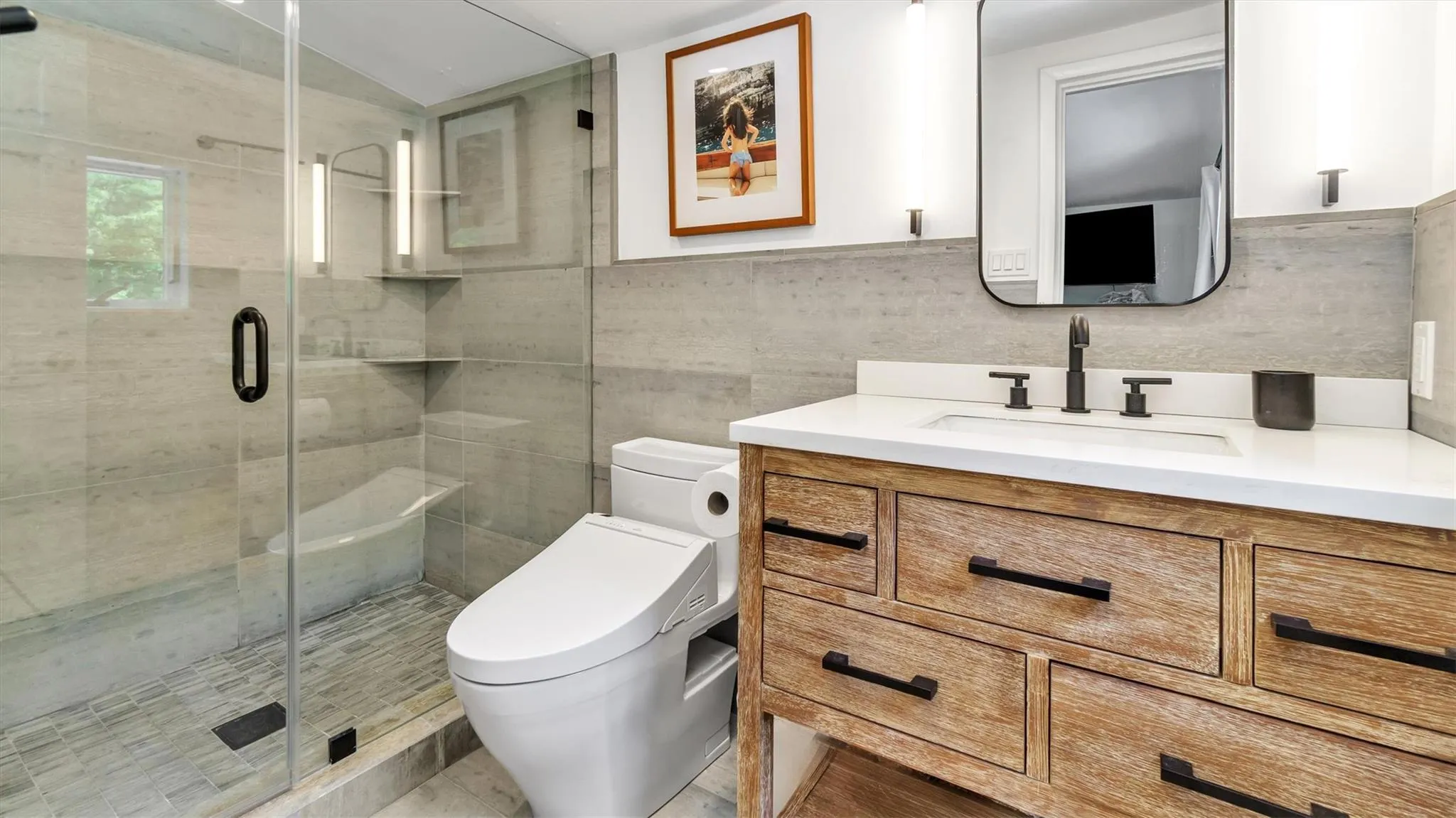 En-suite bathroom with vanity, toilet, a shower stall, and tile walls En-suite bathroom with vanity, toilet, a shower stall, and tile walls