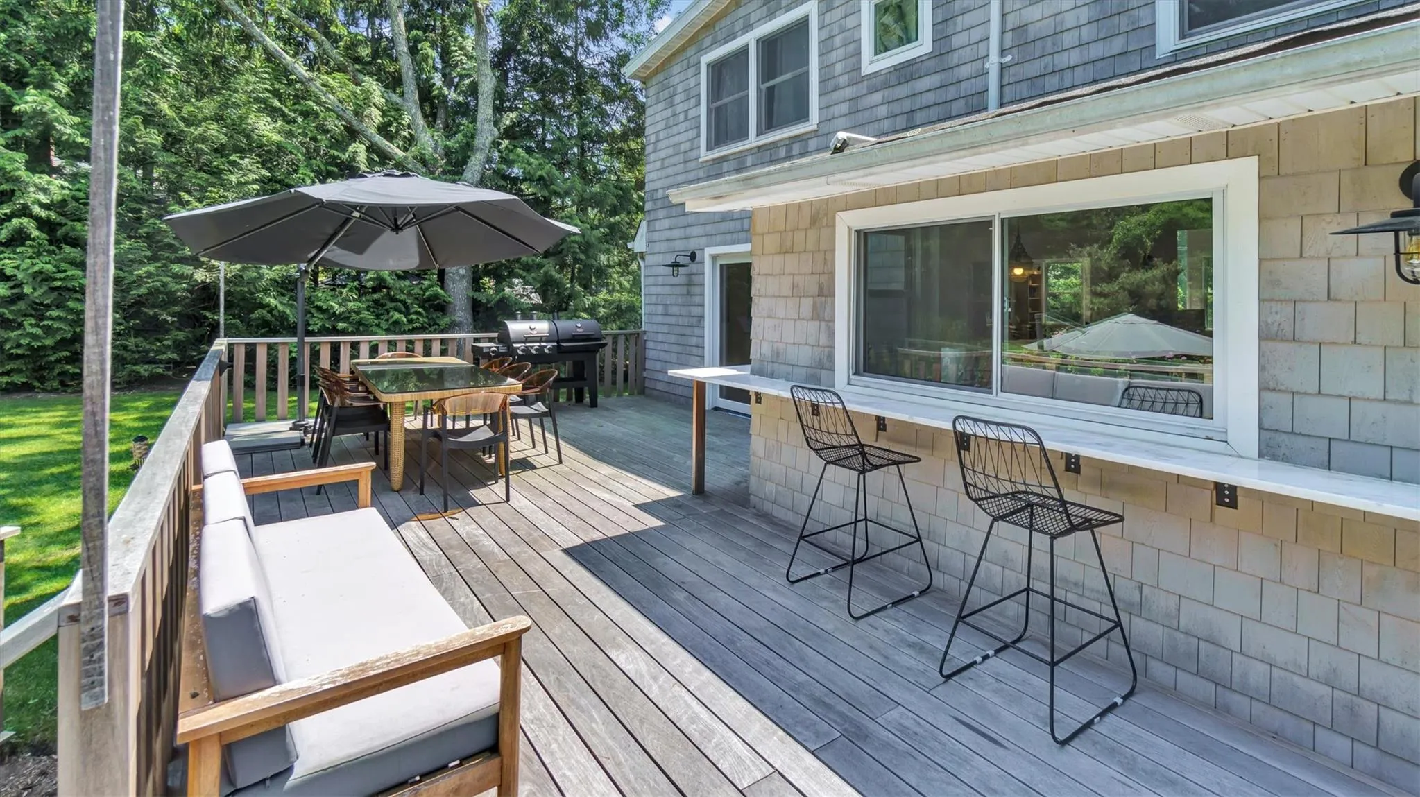 Deck featuring outdoor dining area, grill & bar window Deck featuring outdoor dining area, grill & bar window