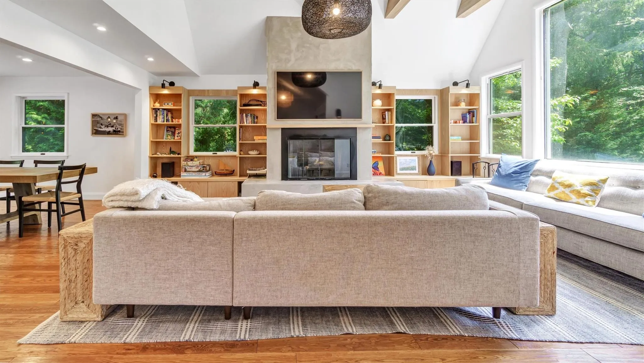 Living room with high ceiling, wood finished floors, plenty of natural light, a glass covered fireplace, and recessed lighting Living room with high ceiling, wood finished floors, plenty of natural light, a glass covered fireplace, and recessed lighting