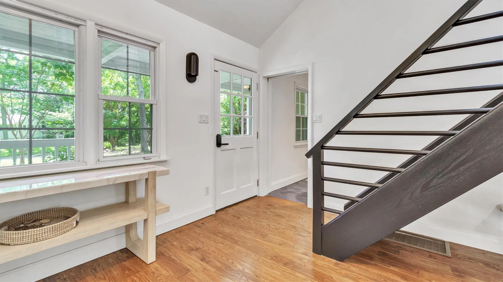 Foyer featuring high ceiling, light wood-style flooring and stairway. Foyer featuring high ceiling, light wood-style flooring and stairway.
